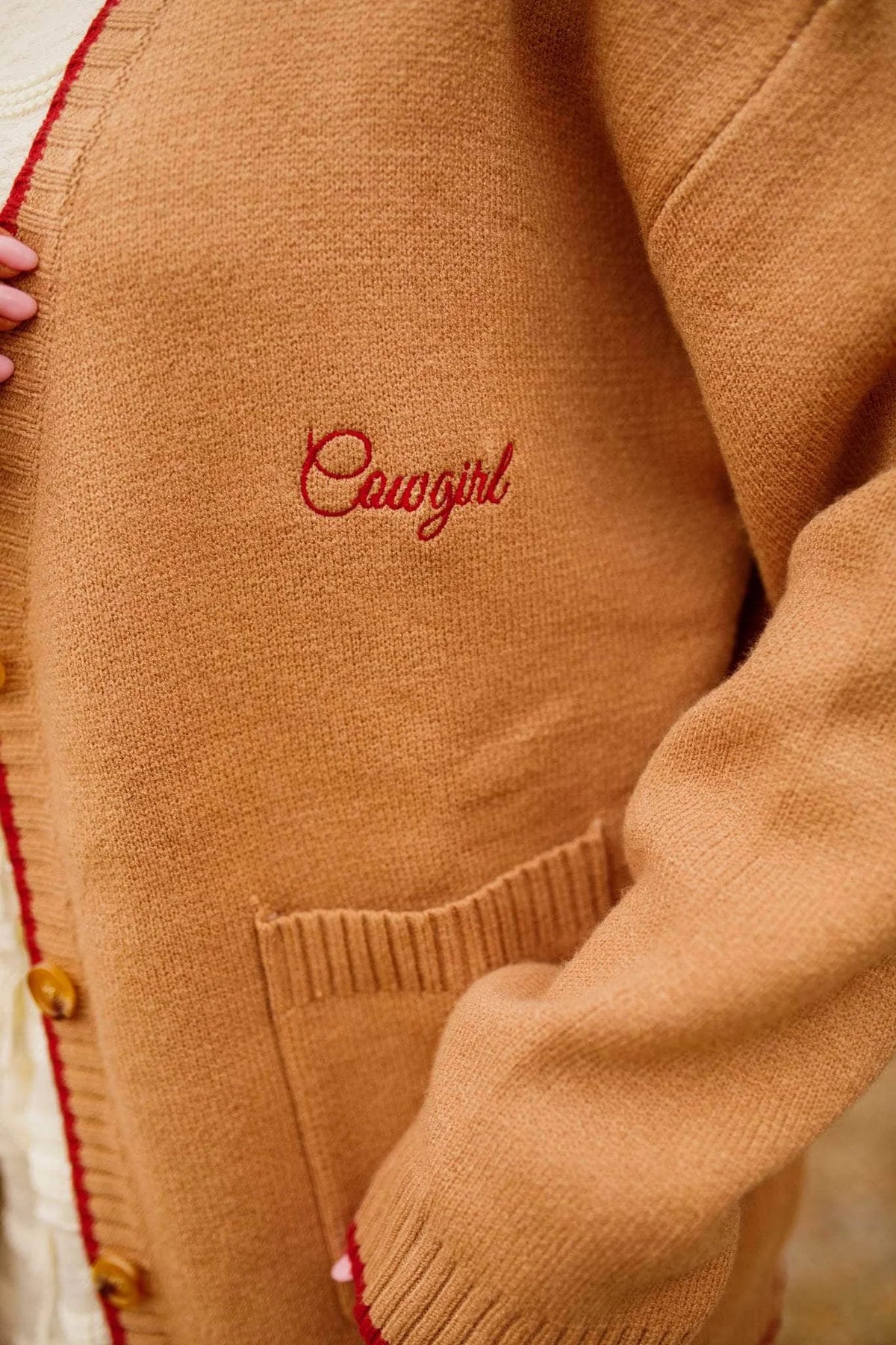 Close-up of a tan cardigan with 'Cowgirl' embroidery on a blurred - Western cardigan, Floral horseshoe sweater, Found my cowboy cardigan, Equestrian-inspired knitwear, Camel embroidered cardiganbackground