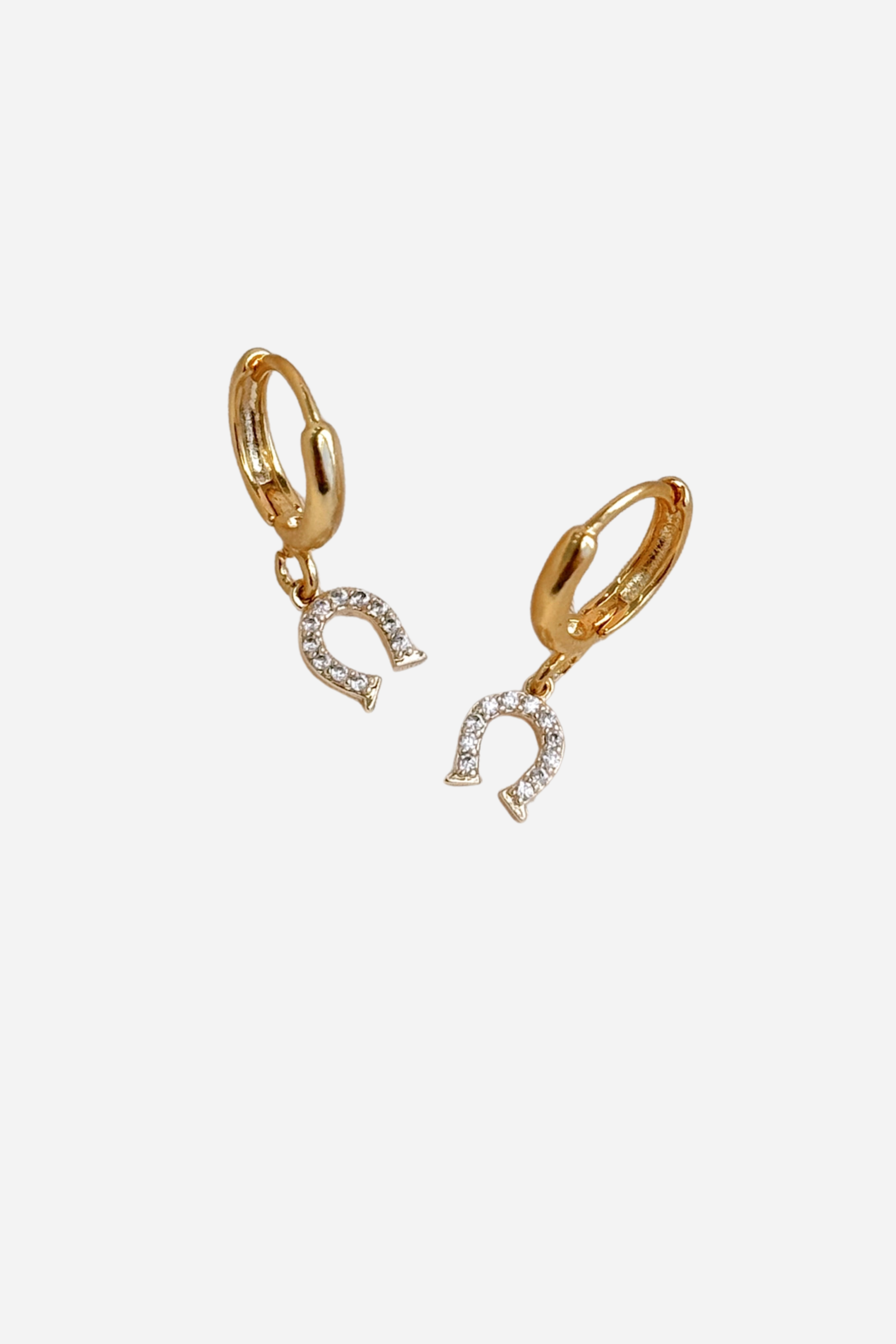 A pair of gold-plated hoop earrings with a dangling horseshoe charm, featuring small clear stones. - equestrian inspired jewelry, horse themed earrings, dainty equestrian jewelry, horseshoe earrings, small gold hoop earrings, small gifts for horse lovers, horse girl accessories