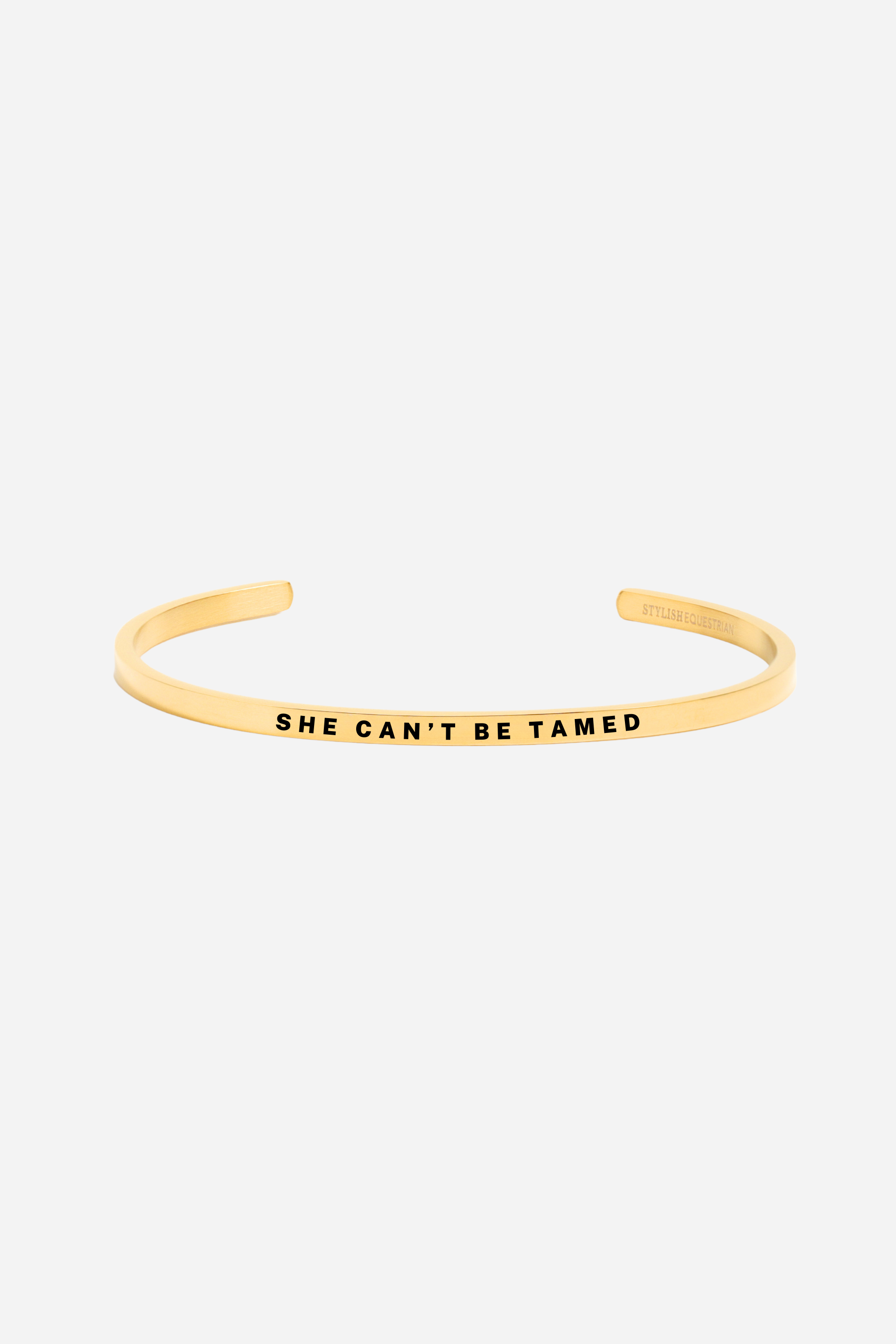“She Can’t Be Tamed” bangle bracelet in silver or gold, crafted from stainless steel with an adjustable, tarnish-resistant finish. A bold equestrian-inspired accessory symbolizing strength and free spirit — perfect for horse lovers.