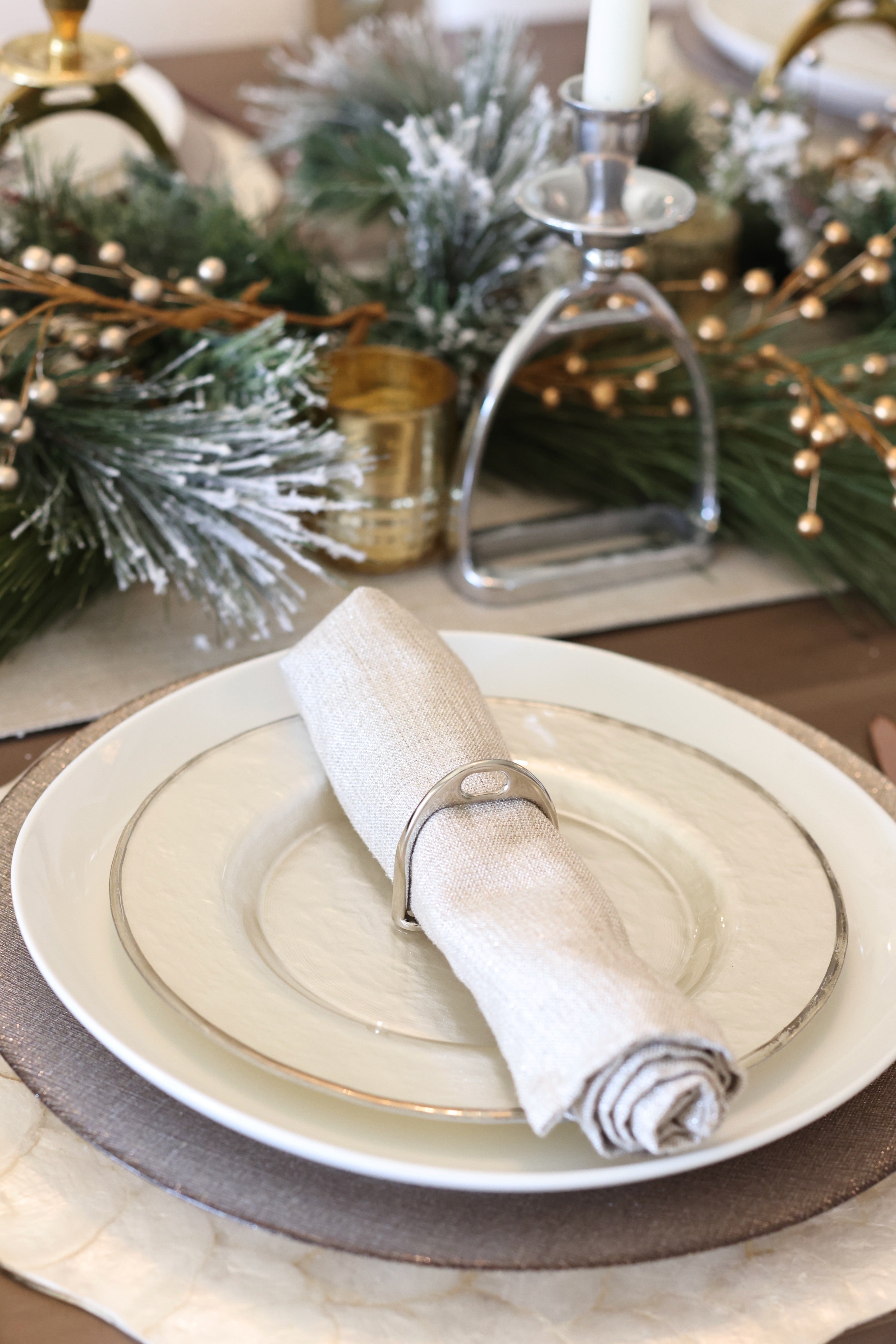 Silver Stirrup Napkin Ring Set featuring four polished silver stirrup-shaped rings with a leather top closure for easy storage. A best-selling equestrian-inspired table accessory perfect for elegant dining or gifting to horse lovers.