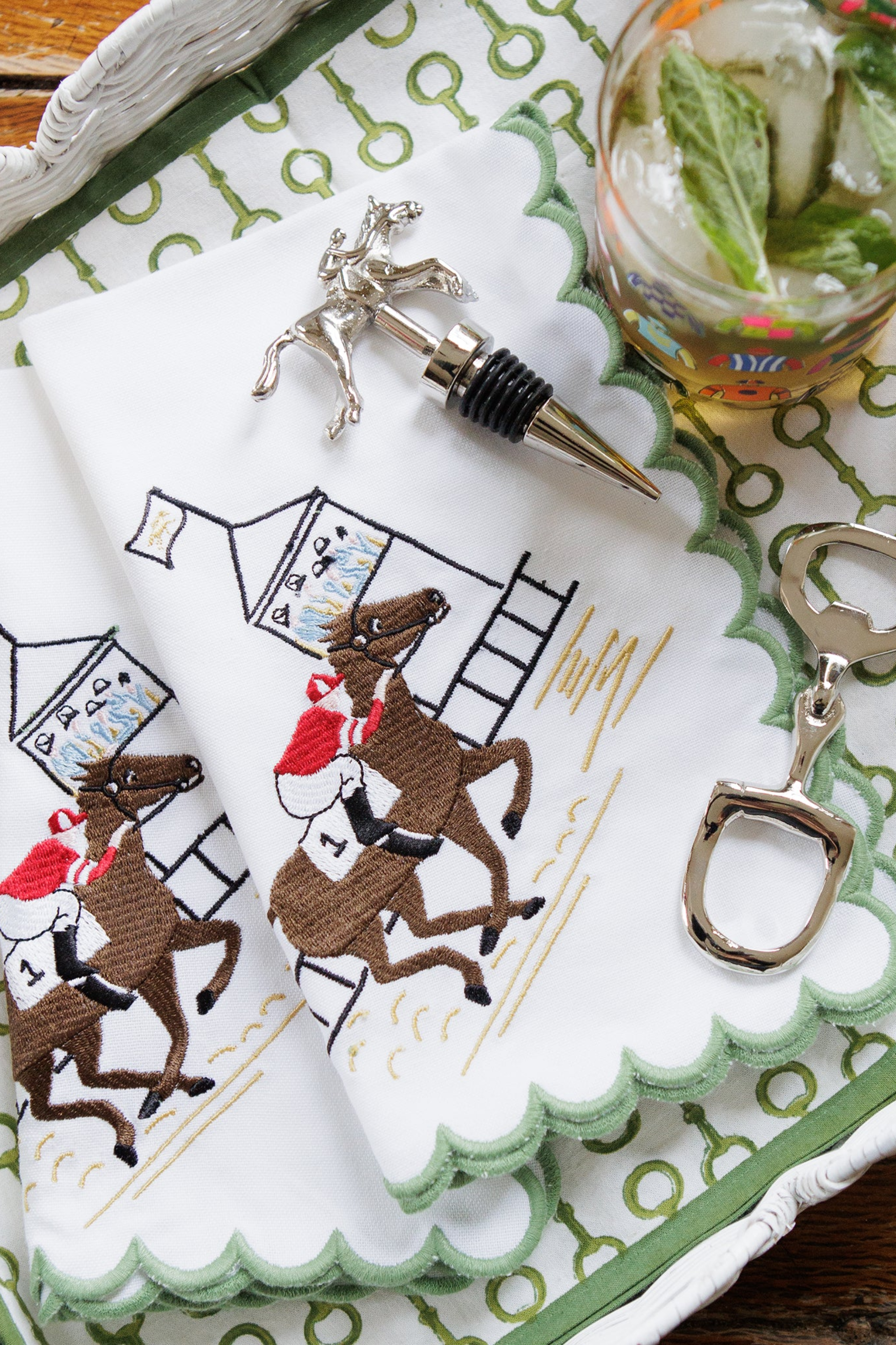 Pomegranate At The Finish Napkin Set Our At the Finish Embroidered Napkins are perfect for both those who know the pulse of a fast-paced finish—and those who just love a beautiful table—these classic cotton napkins feature a striking embroidered scene of a jockey and thoroughbred racing to the finish line. Perfect for Derby dinners, spring brunches, or everyday entertaining, they bring a touch of tradition and a lot of charm to every meal. 