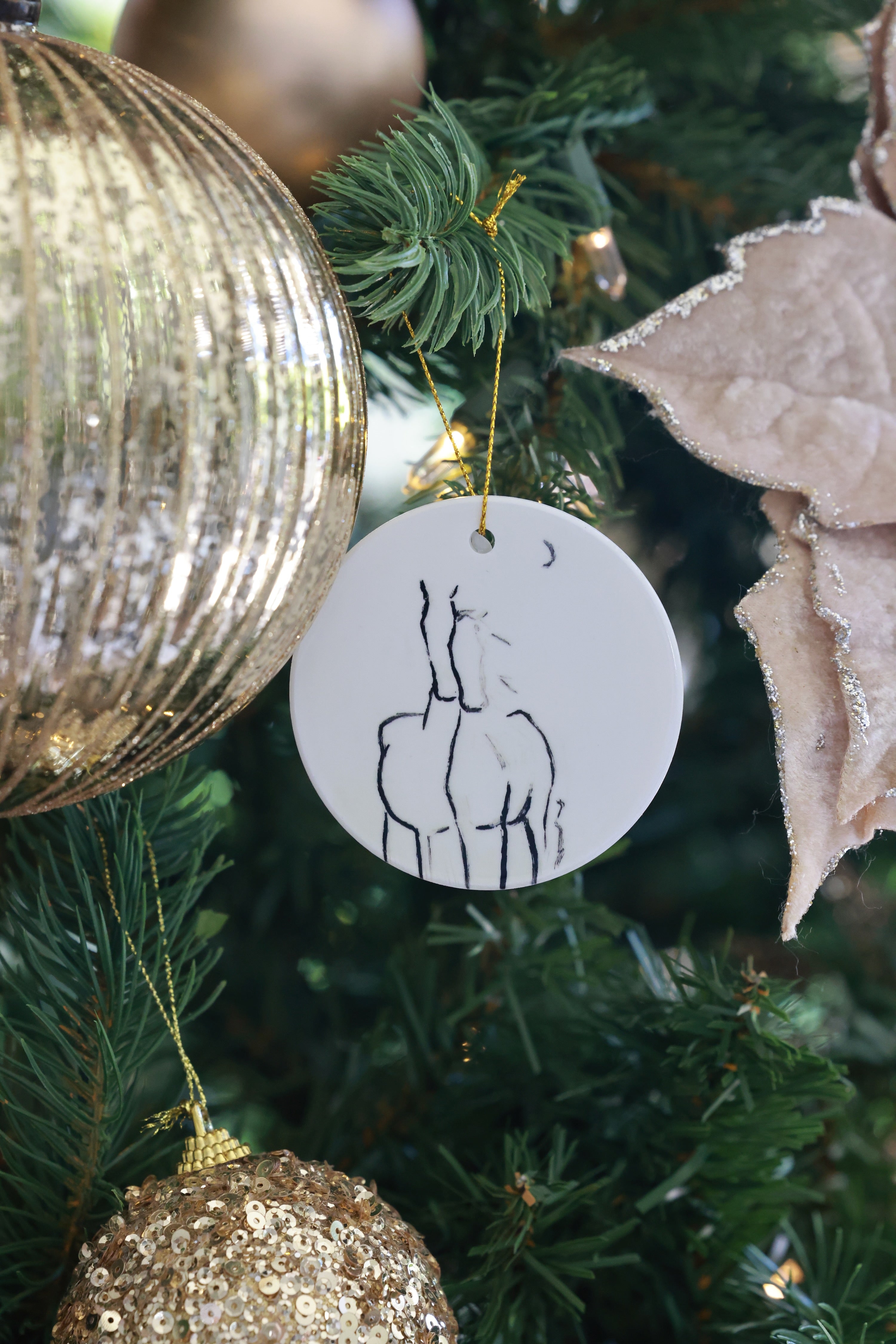 By The Crescent Ornament — ceramic equestrian-inspired Christmas ornament featuring original horse artwork by Bettina, finished with gold tinsel. A beautiful horse-themed holiday decoration and perfect Christmas gift for equestrians and horse lovers. Made in the USA.