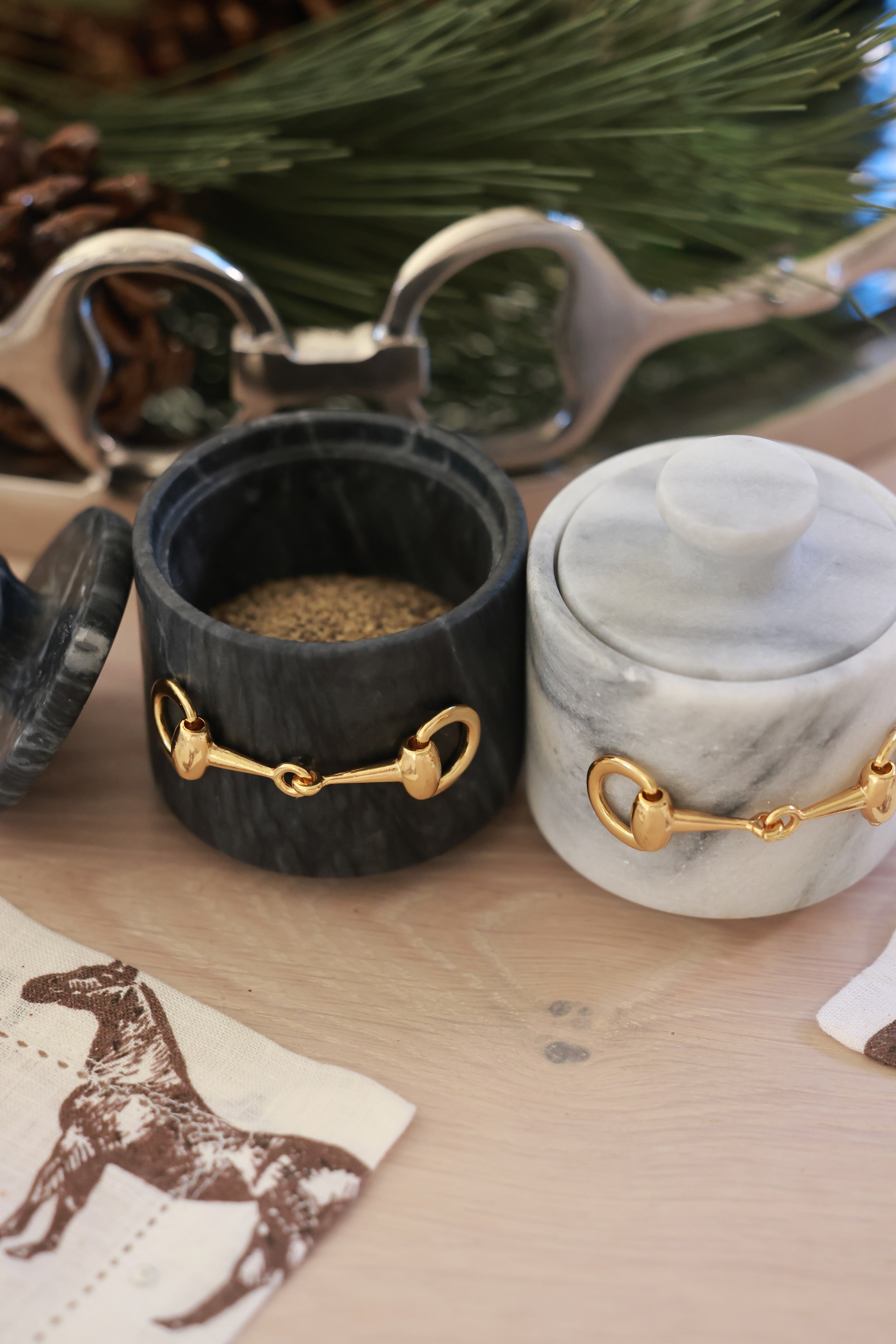 Elegant black marble D-ring salt cellar with gold hardware and matching lid, handcrafted for an equestrian-inspired kitchen. The round marble container features a sleek matte finish and natural veining, perfect for storing gourmet salts, spices, or herbs while adding sophisticated horse-themed decor to any table or countertop.