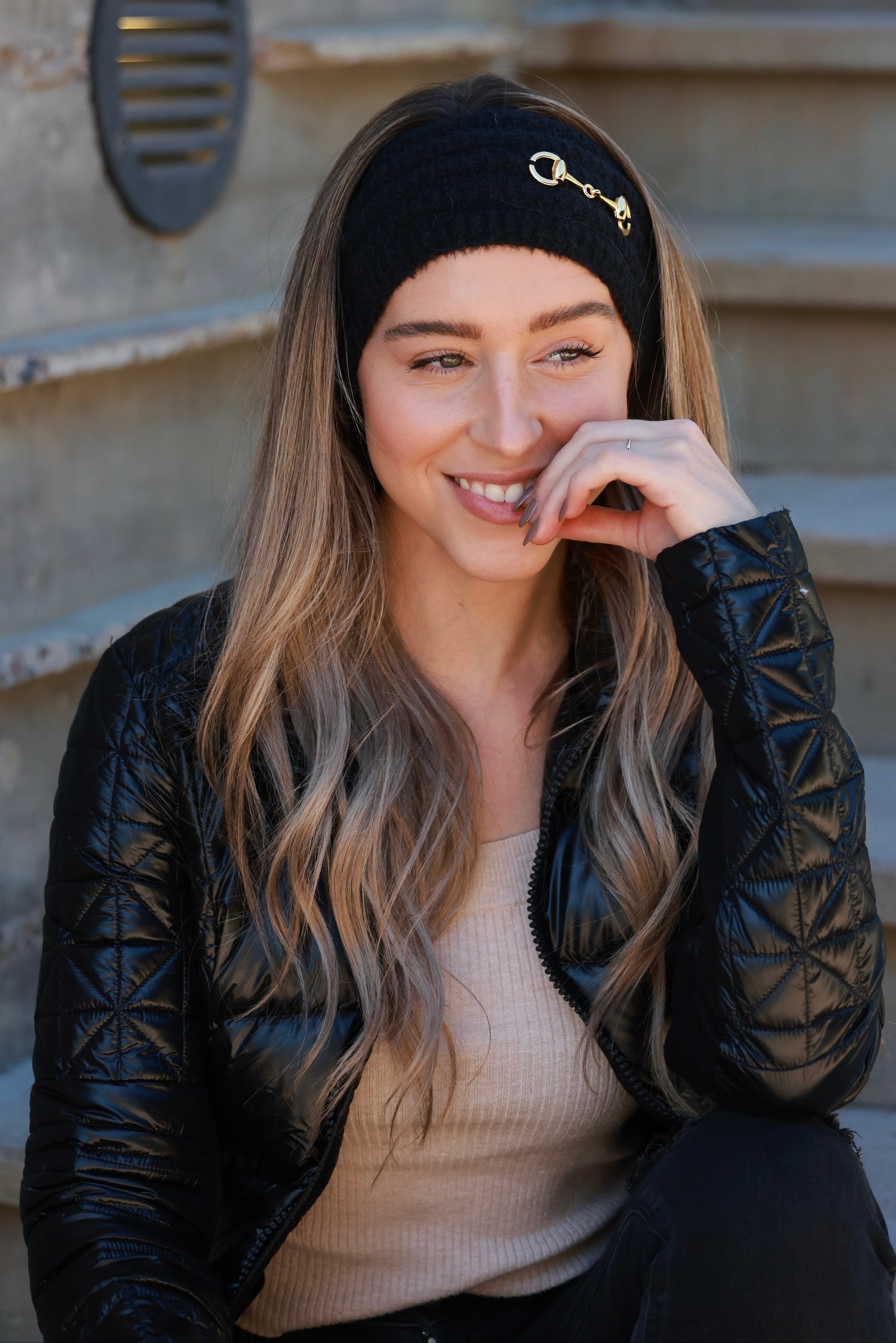 Black Elsie Knit Headband featuring soft, stretchy knit fabric and a gold bit accent. Comfortable, secure fit adds a touch of equestrian elegance to any cold-weather look.
