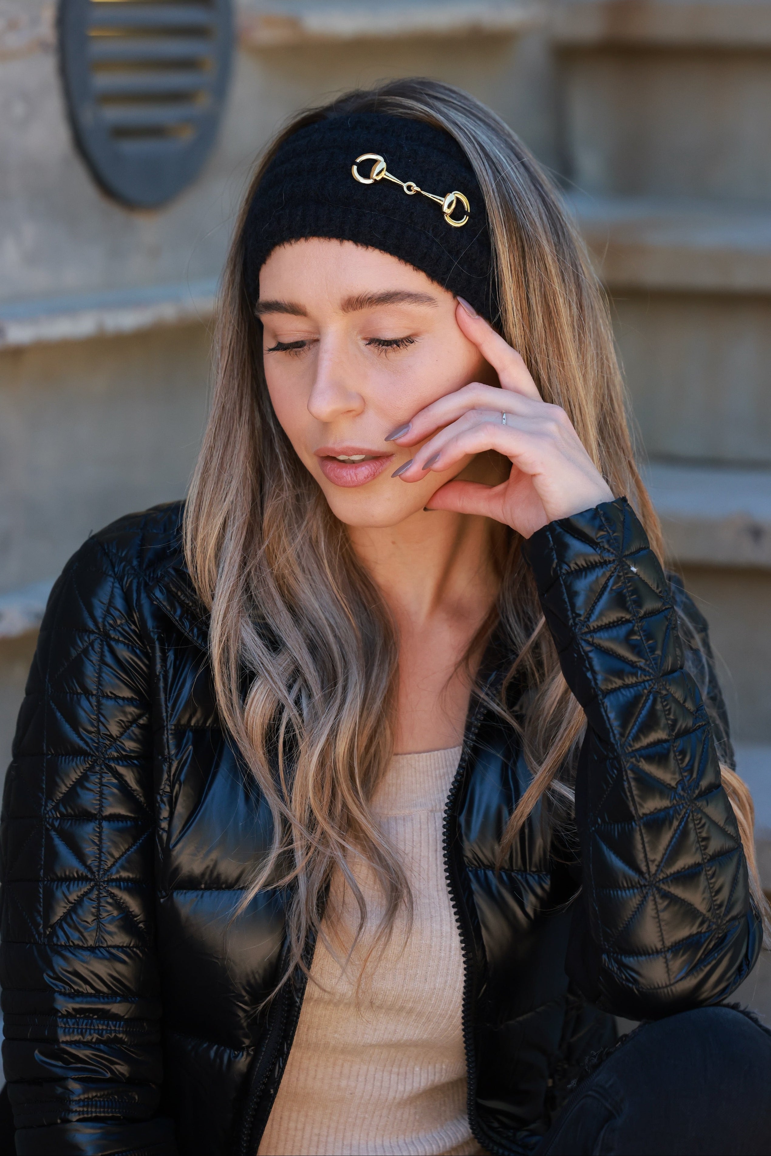 Black Elsie Knit Headband featuring soft, stretchy knit fabric and a gold bit accent. Comfortable, secure fit adds a touch of equestrian elegance to any cold-weather look.