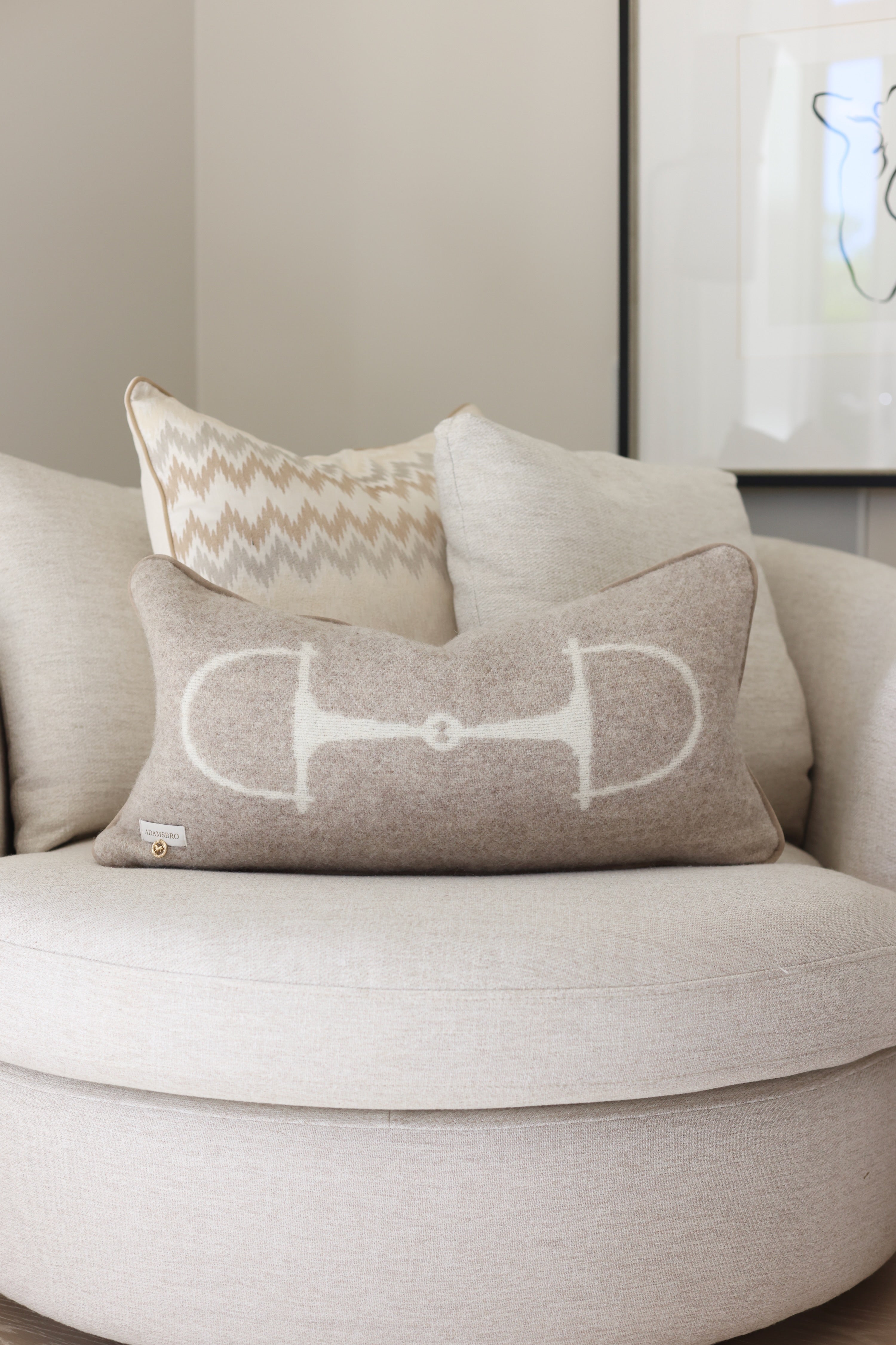 Equine Lumbar Wool Pillow - Vanilla Bean A Luxury rectangular cushion in vanilla bean, made from 100% New Zealand lambswool with ADAMSBRO’s signature equestrian bit pattern. Handcrafted in Sweden, featuring faux suede piping, concealed zipper, and a plush duck feather insert, a refined accent for timeless, Scandinavian-inspired interiors.