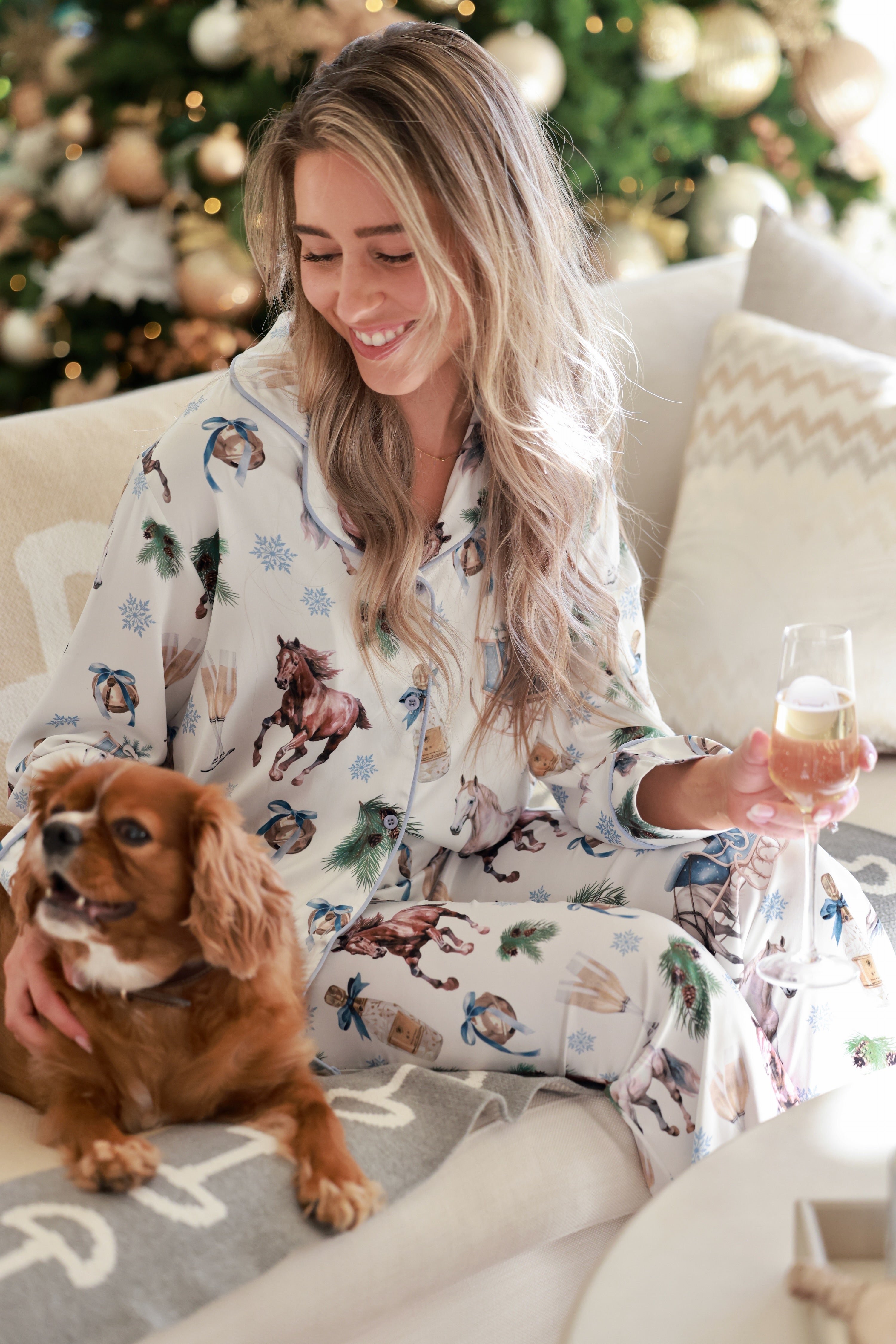 Silky satin equestrian-themed pajama set featuring a gold and ivory sleigh ride print, classic button-up long sleeve top with lapel collar, and matching full-length pants with elastic waist—luxurious and festive sleepwear for the season.
