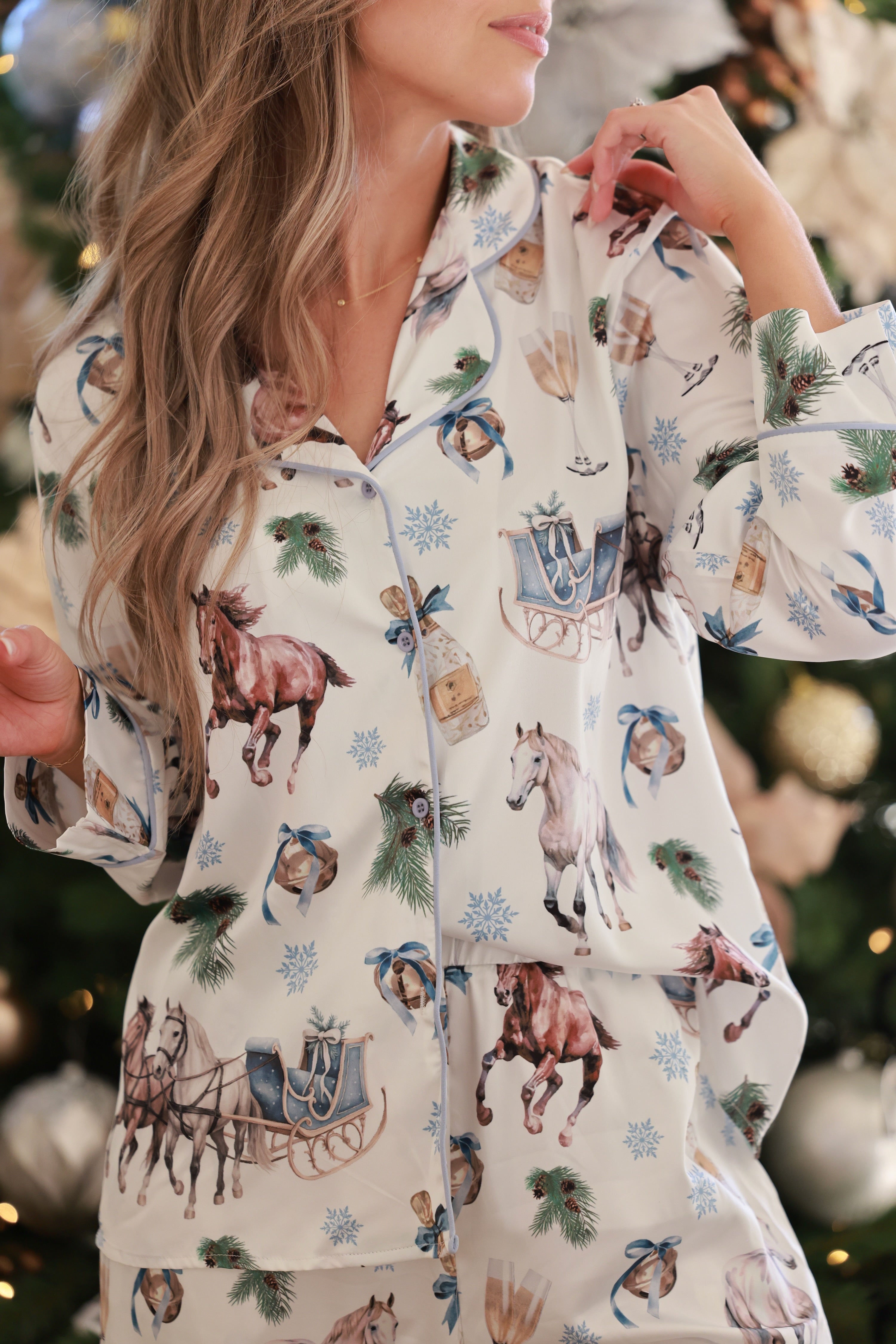 Silky satin equestrian-themed pajama set featuring a gold and ivory sleigh ride print, classic button-up long sleeve top with lapel collar, and matching full-length pants with elastic waist—luxurious and festive sleepwear for the season.