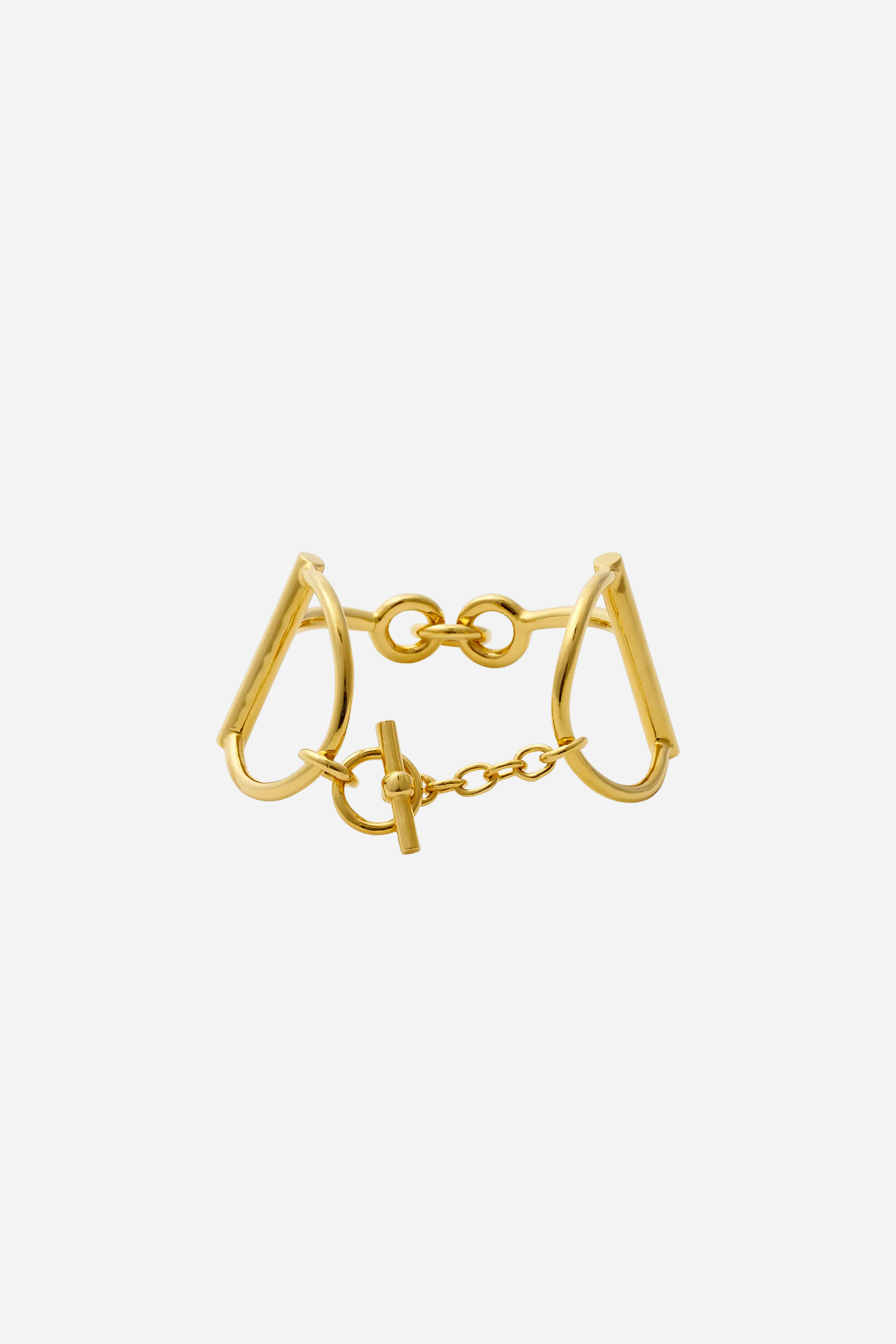Heritage Horse Bit Gold Cuff — a bold, polished gold-over-brass bracelet with a sleek, modern open-triangle design, 1½-inch width, and iconic double horse-bit motif, connected by small links and secured with a signature toggle-and-ring clasp, elegantly curved to fit a 7½-inch wrist, photographed on a white background.