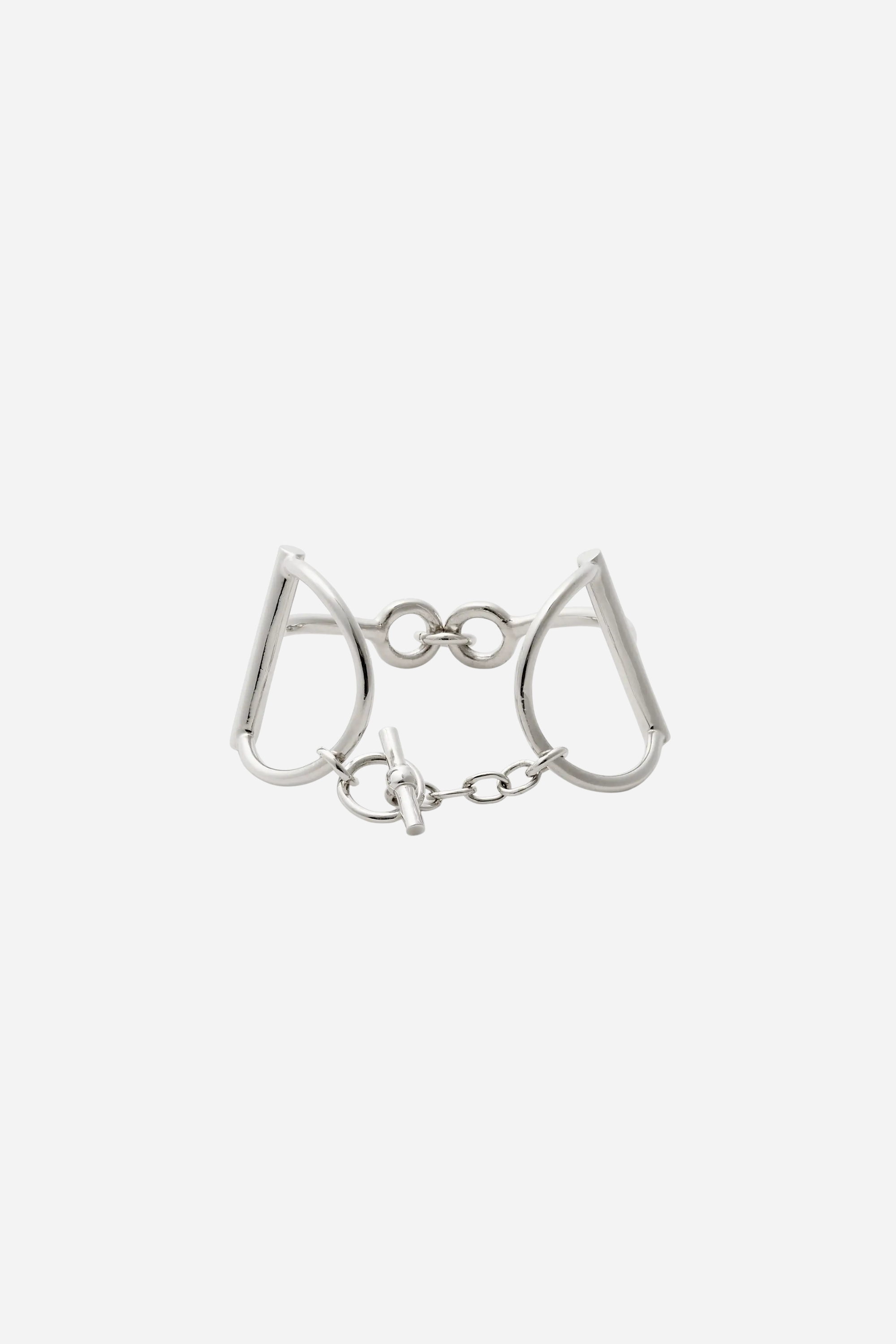 Heritage Bit Bracelet – Silver: a polished, hand-cast 925 sterling silver bracelet featuring geometric shapes and interlocking loops, bold 1½-inch width, and iconic double horse-bit design. Linked by a delicate chain with a signature toggle-and-ring clasp, elegantly curved to fit a 7½-inch wrist, showcasing a modern, minimalist, yet substantial equestrian style.
