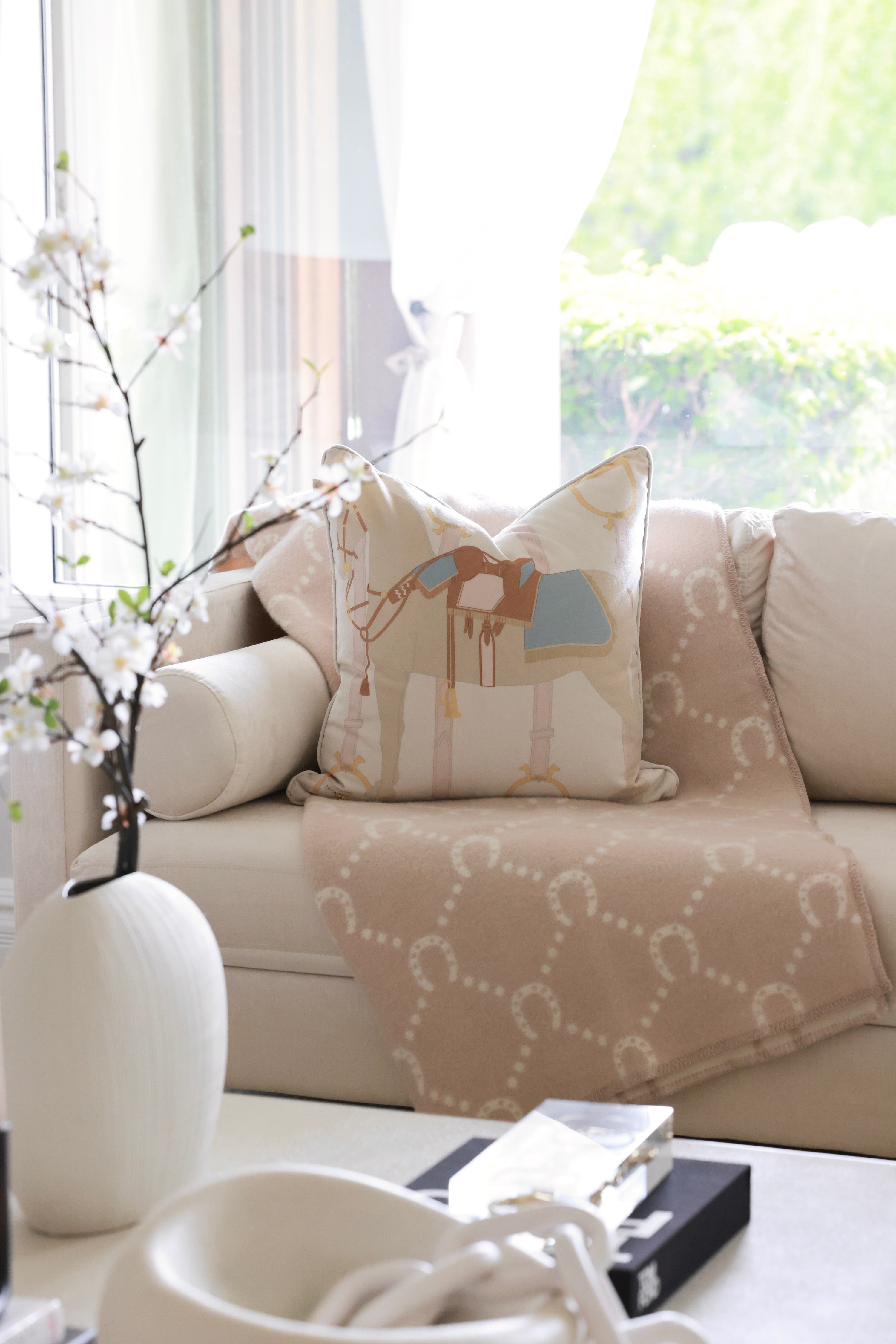 Heritage Horse pastel velvet pillow with equestrian-inspired design, luxury home décor cushion in off-white and beige tones, soft feather-filled insert, perfect for living rooms, bedrooms, or tack rooms. Decorative pillow with a soft brown horse design, featuring a blue and brown saddle. The background is light beige with subtle equestrian-themed accents. 