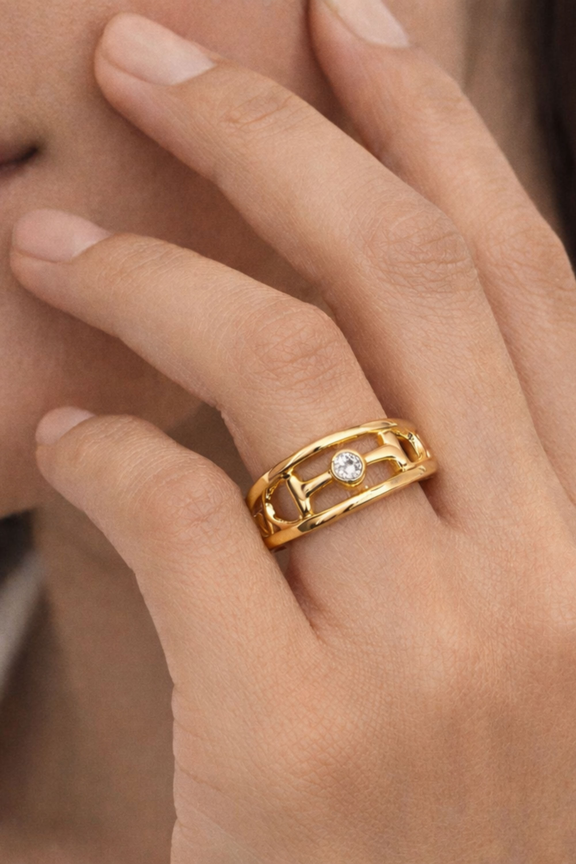 18k gold dipped Hollis double band ring featuring an equestrian horse bit centerpiece with a bezel-set crystal accent.