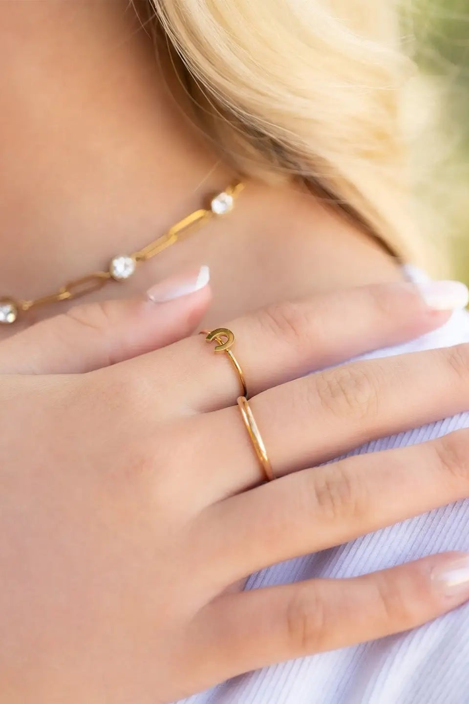 Close-up of a hand wearing gold rings with a blurred background - equestrian accessory, horse themed jewelry, horseshoe ring, stacking ring, minimal equestrian ring, gifts for horse lovers