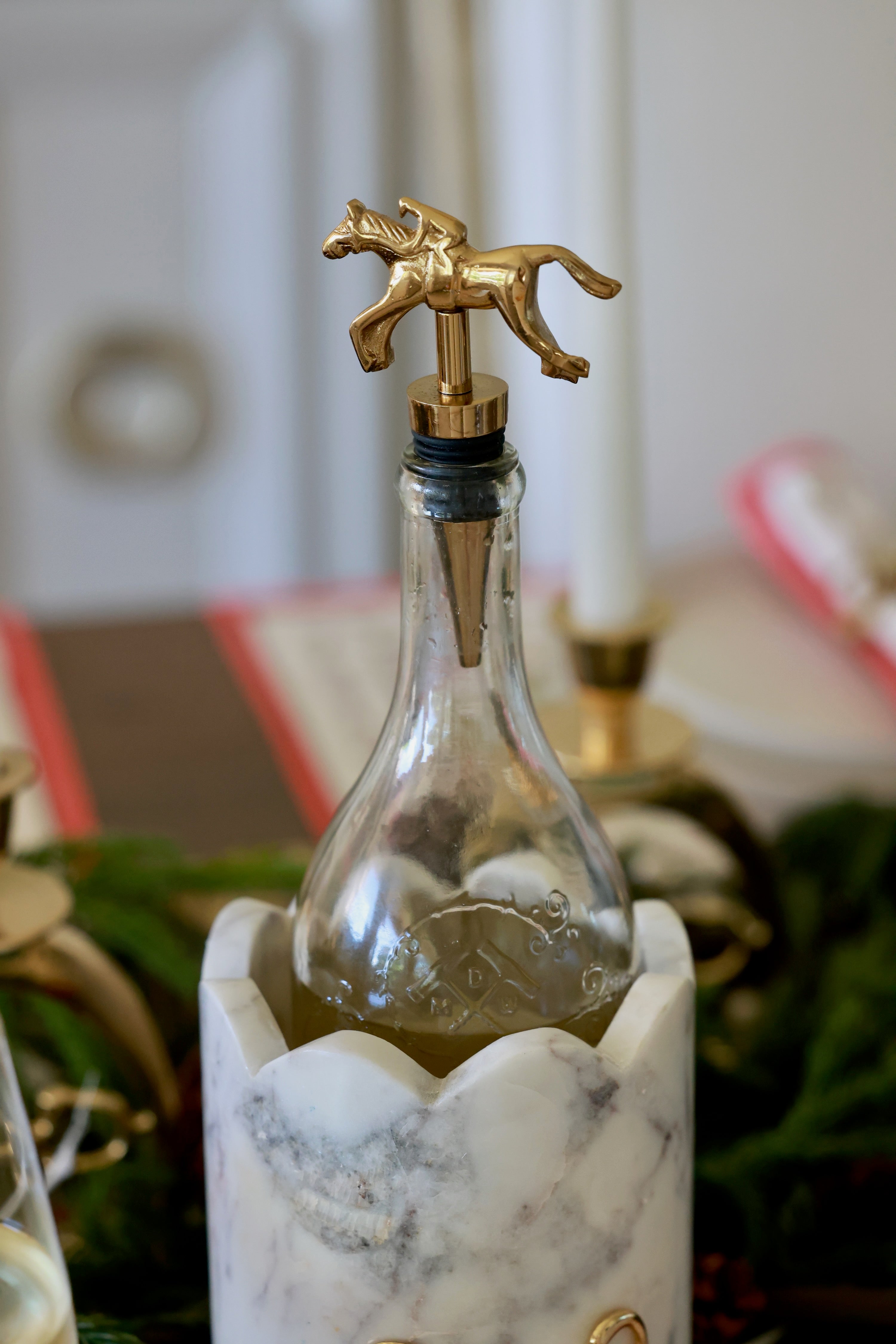 Pomegranate Jockey Bottle Stopper - Gold Elevate your entertaining with the Gold Jockey Bottle Stopper. Crafted with a charming horse & jockey design, this stopper not only preserves your wine's freshness but also adds a touch of equestrian elegance to your barware. Its durable construction ensures a secure fit, making it a delightful gift for horse lovers and wine enthusiasts alike.