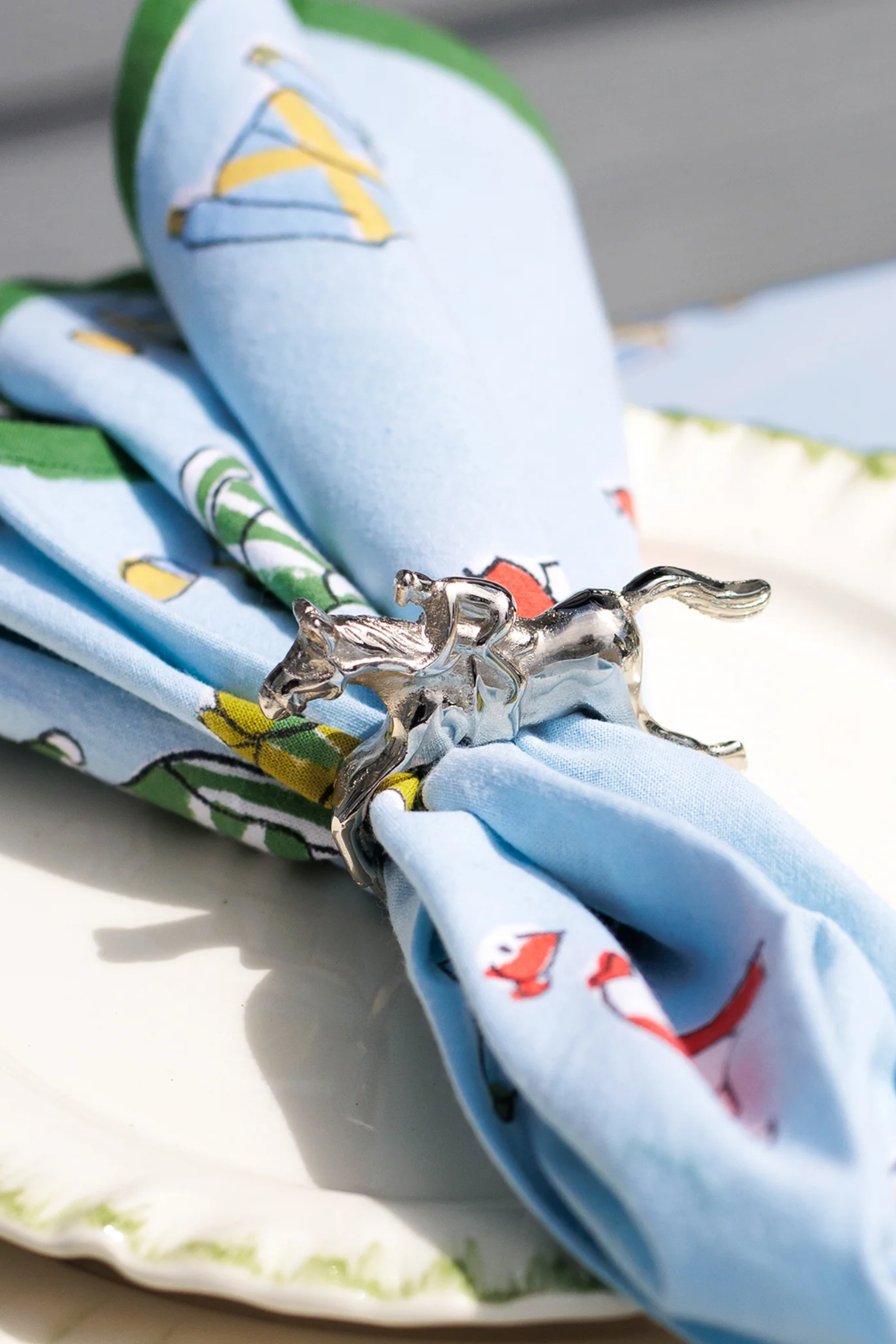 Pomegranate Jockey Napkin Ring Set - Silver Bring a touch of luxury to your table with the Silver Jockey Napkin Rings. This set of four features a stunning horse & jockey design that shines at every gathering. Ideal for formal dinners or casual brunches, these napkin rings are the perfect accessory to elevate your dining decor.