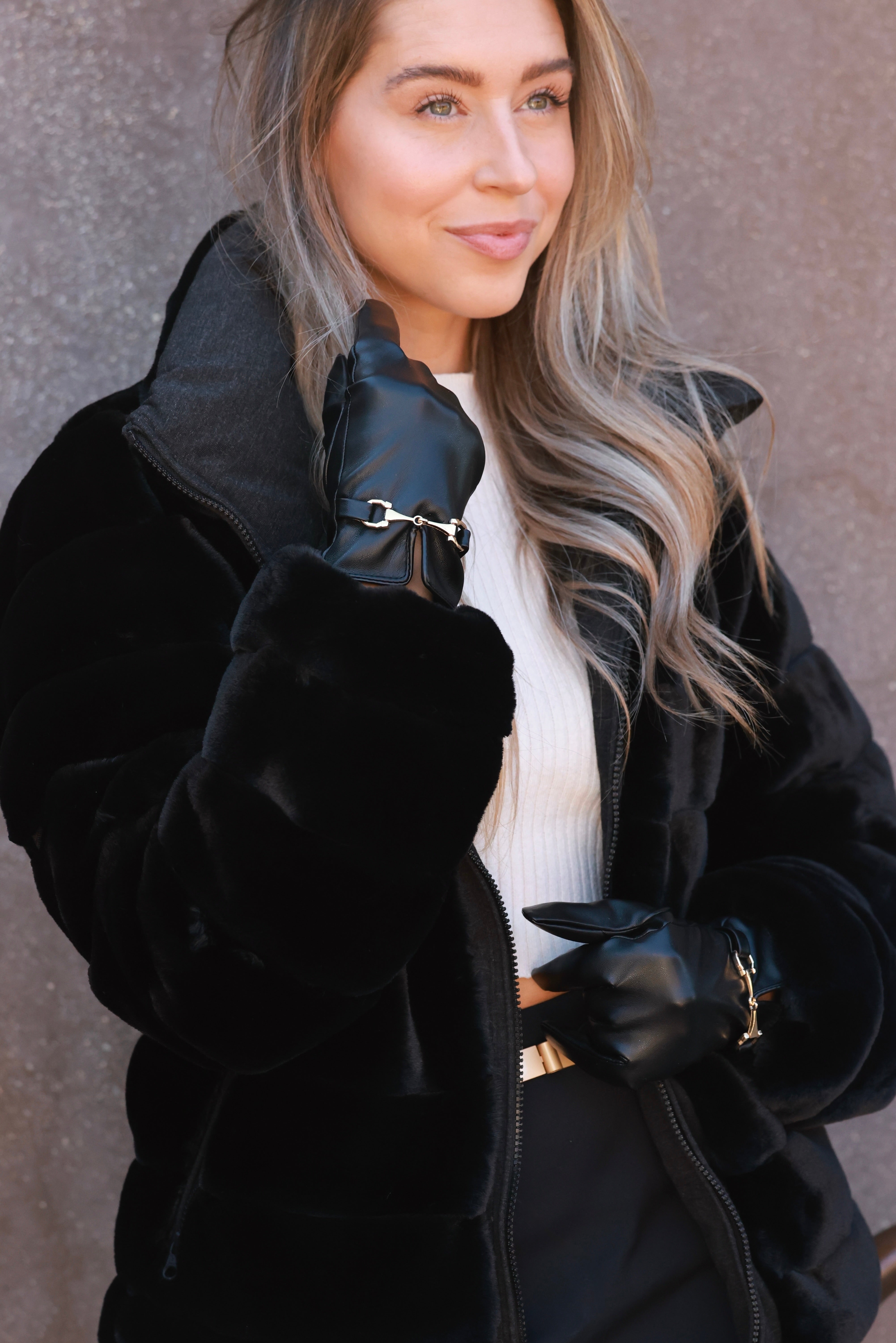 Classic black faux-leather gloves featuring a plush faux-fur lining and a gold horse bit detail at the wrist. Sophisticated equestrian-inspired design with a chic, tailored finish.