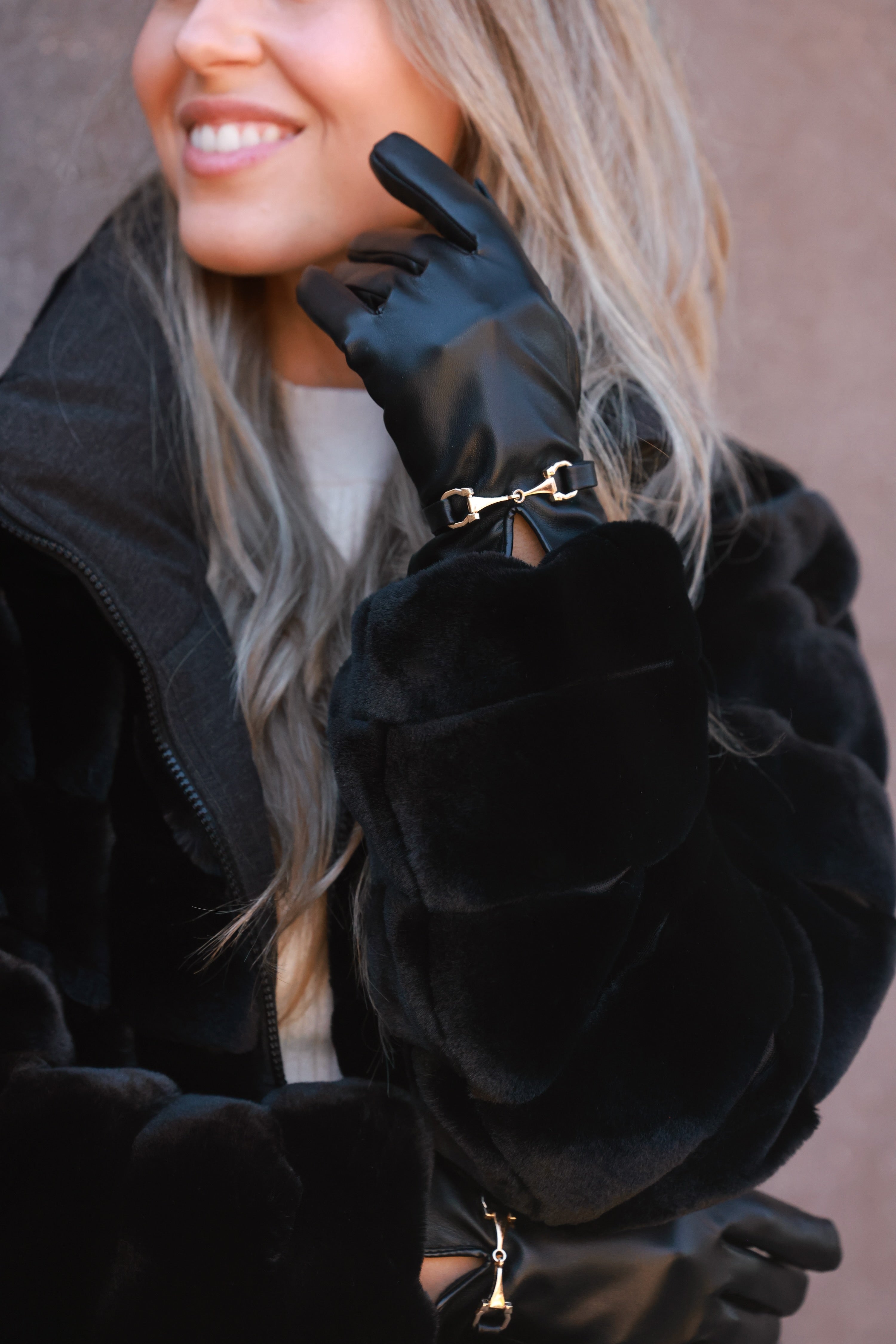 Classic black faux-leather gloves featuring a plush faux-fur lining and a gold horse bit detail at the wrist. Sophisticated equestrian-inspired design with a chic, tailored finish.