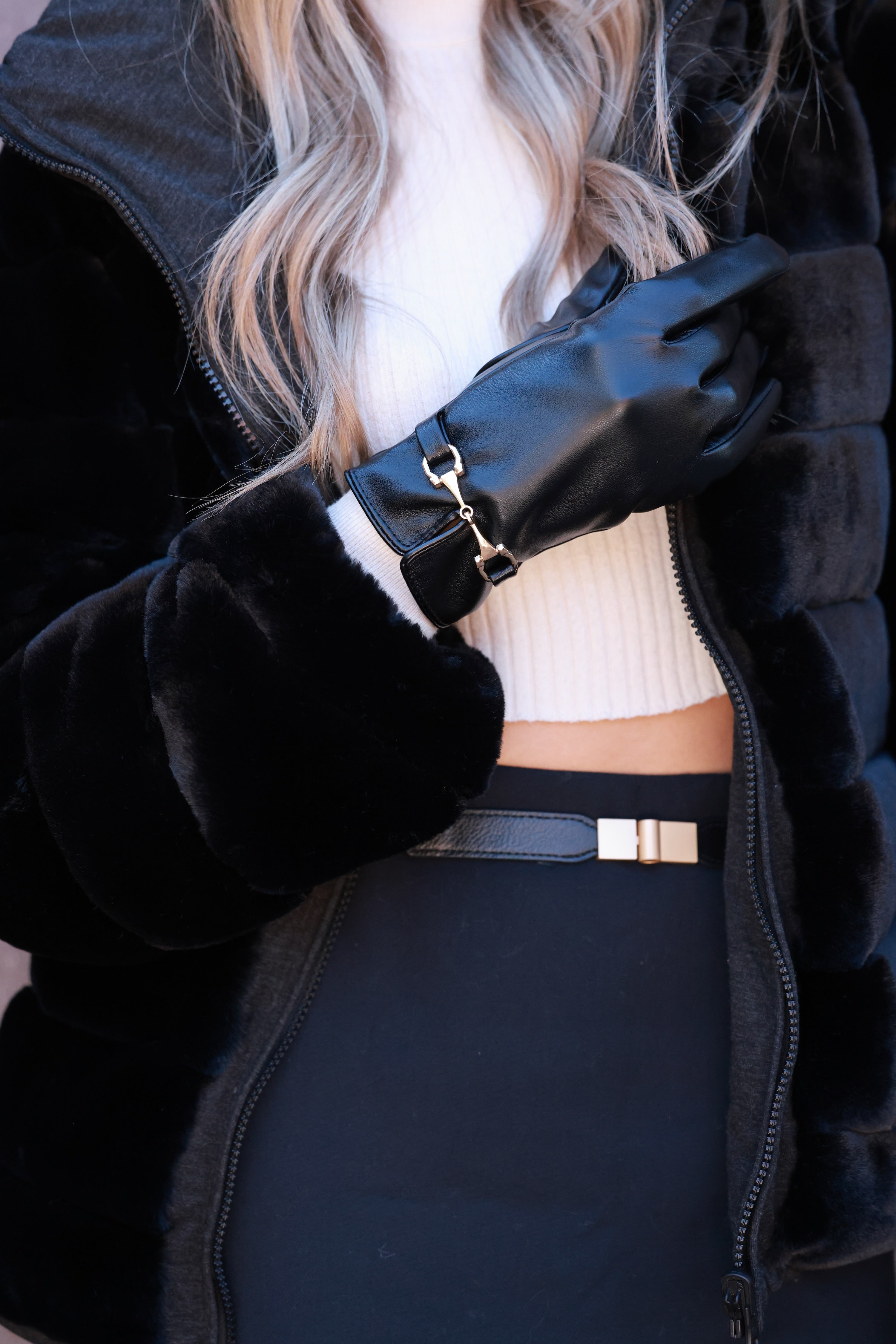 Classic black faux-leather gloves featuring a plush faux-fur lining and a gold horse bit detail at the wrist. Sophisticated equestrian-inspired design with a chic, tailored finish.