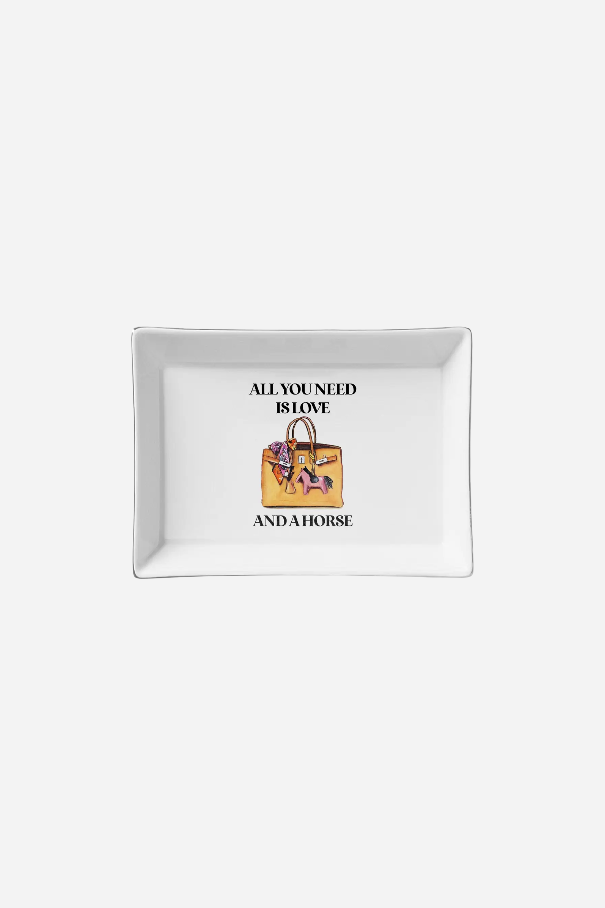 Rectangular white ceramic trinket tray measuring 6.5 x 4.5 inches, featuring the phrase 'All you need is love and a horse' with an illustrated handbag and pink horse figurine. Playful and practical design, perfect for holding jewelry or small items.