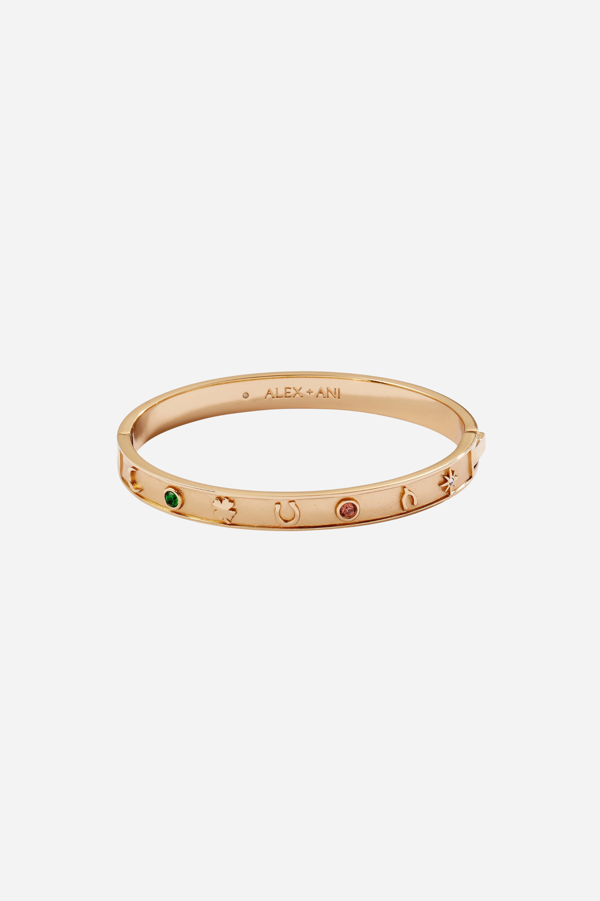 Gold hinge bangle bracelet featuring lucky charm symbols—horseshoe, wishbone, and four-leaf clover—accented with colored crystal details.