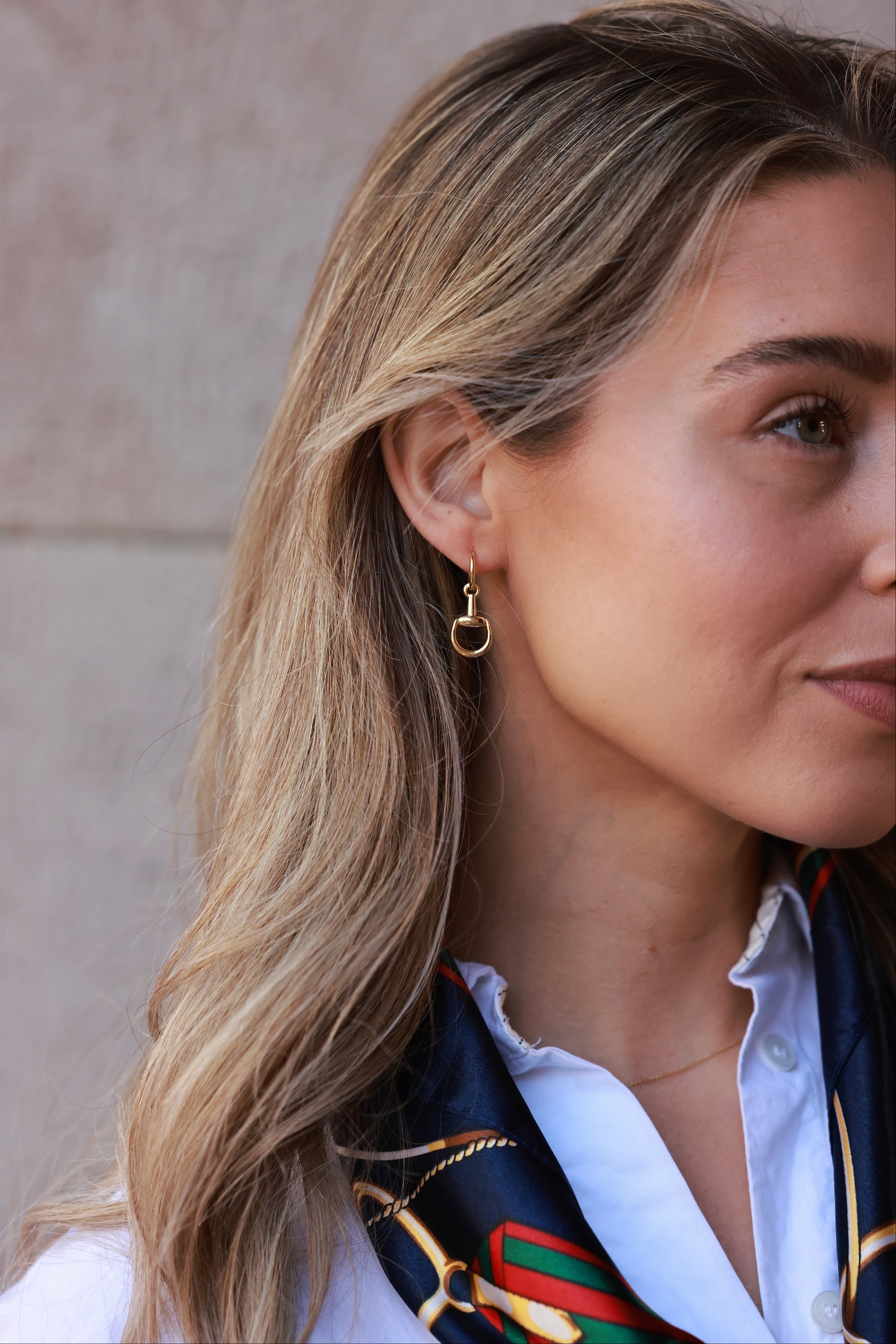 Gold equestrian huggie hoop earrings with stirrup design, lightweight 18k gold horse bit jewelry, dainty horse girl earrings, elegant gift for equestrian lovers.