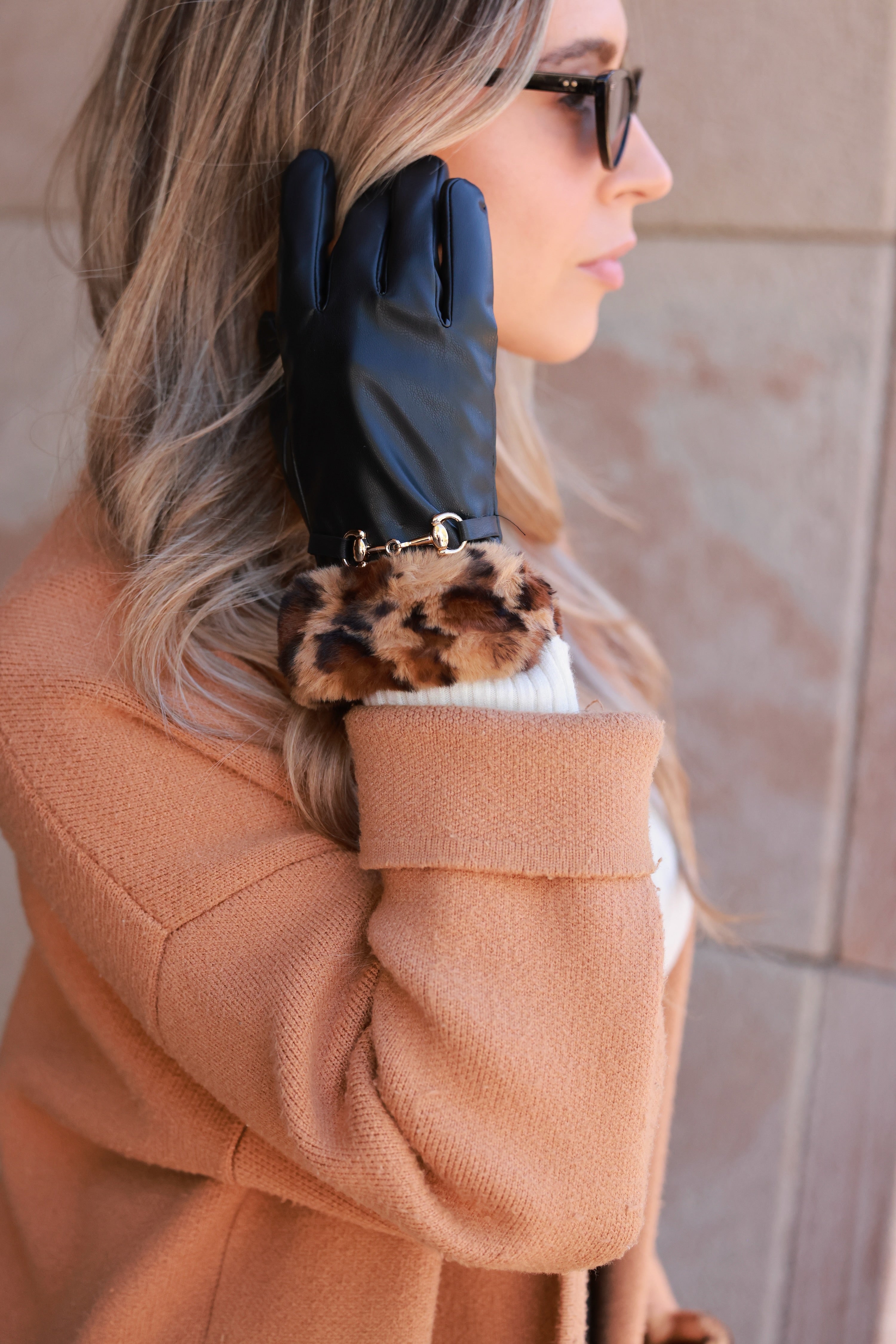 Meredith Horse Bit Gloves crafted from supple polyurethane leather with soft faux-fur lining, chic leopard print cuffs, and polished gold horse bit detail. Elegant equestrian cold-weather accessory combining warmth, style, and sophistication.