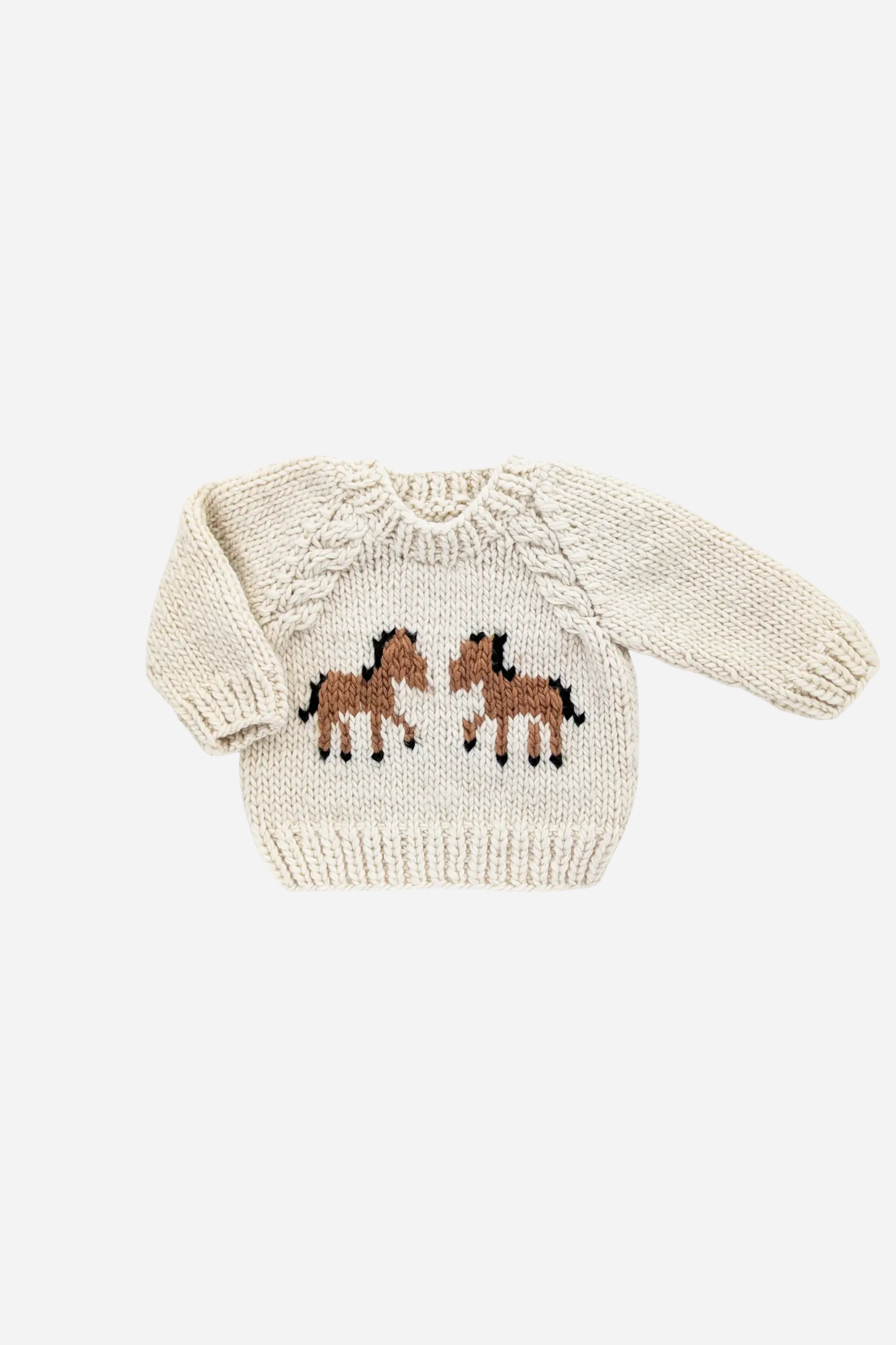 Handmade kids’ pony sweater in soft natural yarn, featuring a cute pony design on the front, raglan sleeves, and cable knit accents. Cozy, sustainable equestrian-inspired children’s clothing made from recycled polyester and acrylic blend.