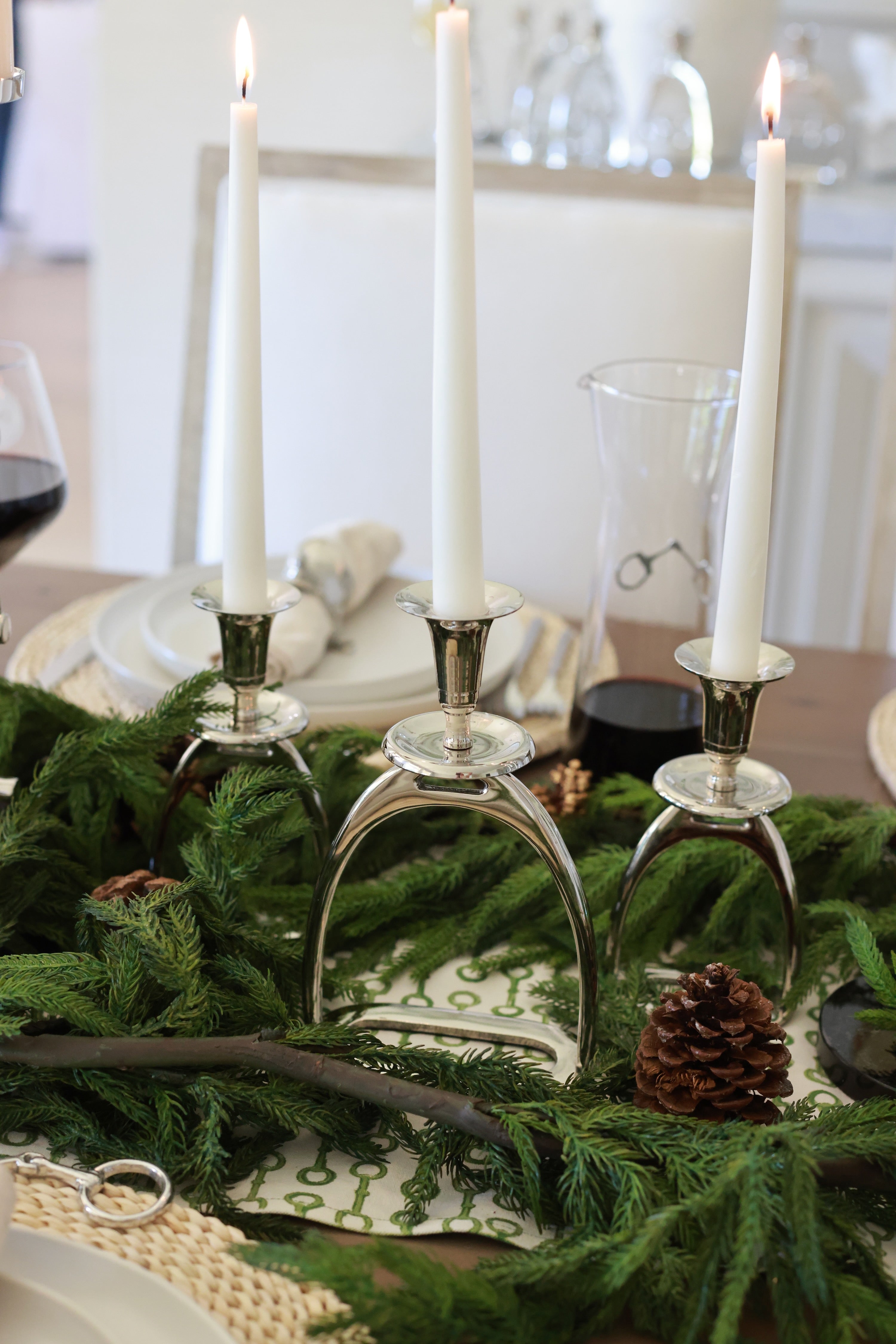 Silver Stirrup Candle Holder featuring a polished equestrian stirrup design that holds tapered candles. Available in small (6") and large (10") sizes, this elegant home accent adds refined equestrian charm to any space.