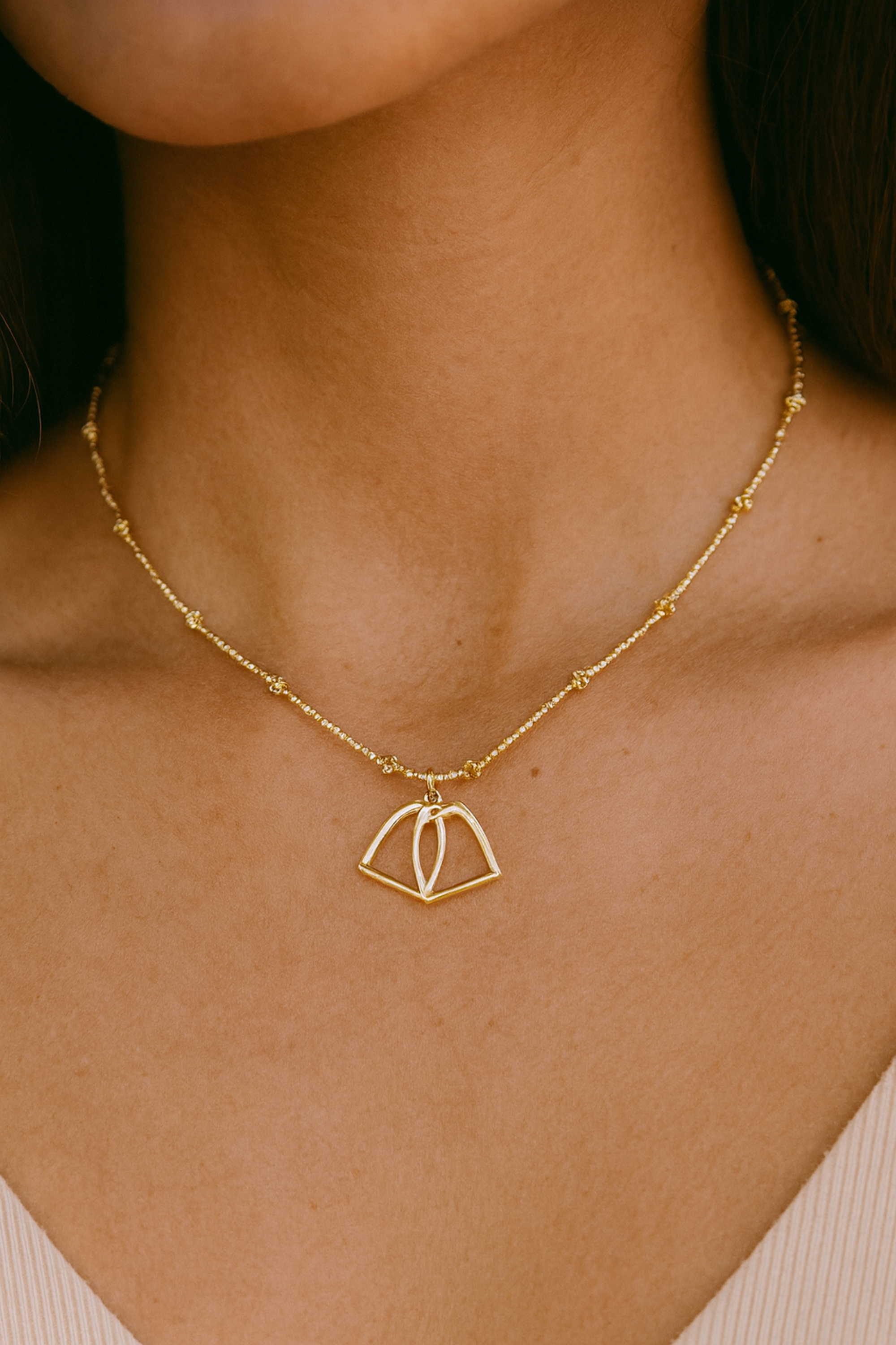 Delicate and dazzling stirrup necklace with lightweight stirrups strung between shimmering beads. 15-inch length with adjustable extender chain.