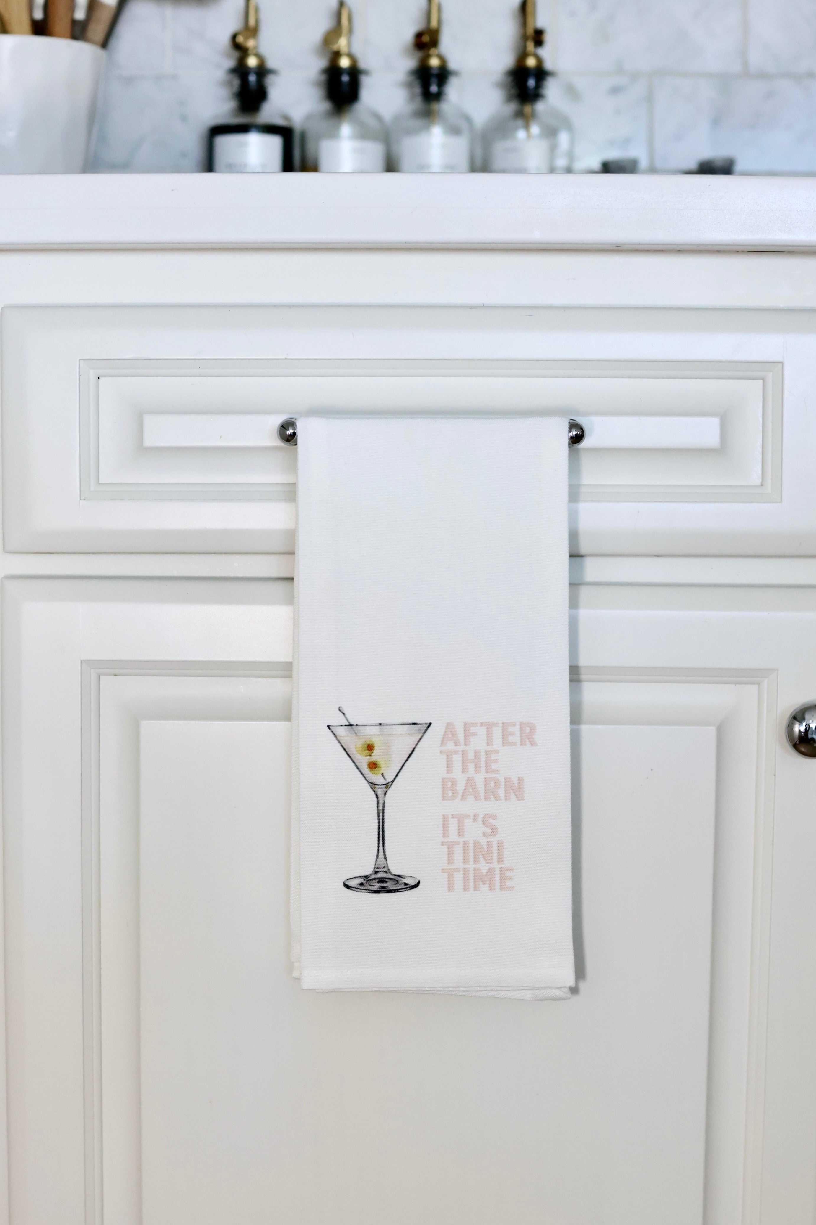 Toss Designs Tini Time Hand Towel | White tea towel featuring an illustration of a martini with olives and text "After the barn it's 'tini time," | Tini Time hand towel, equestrian tea towel, horse lover kitchen towel, funny bar towel, martini tea towel with olives, after the barn towel, stylish equestrian home decor, polyduck tea towel, horse girl gift, made in USA hand towel