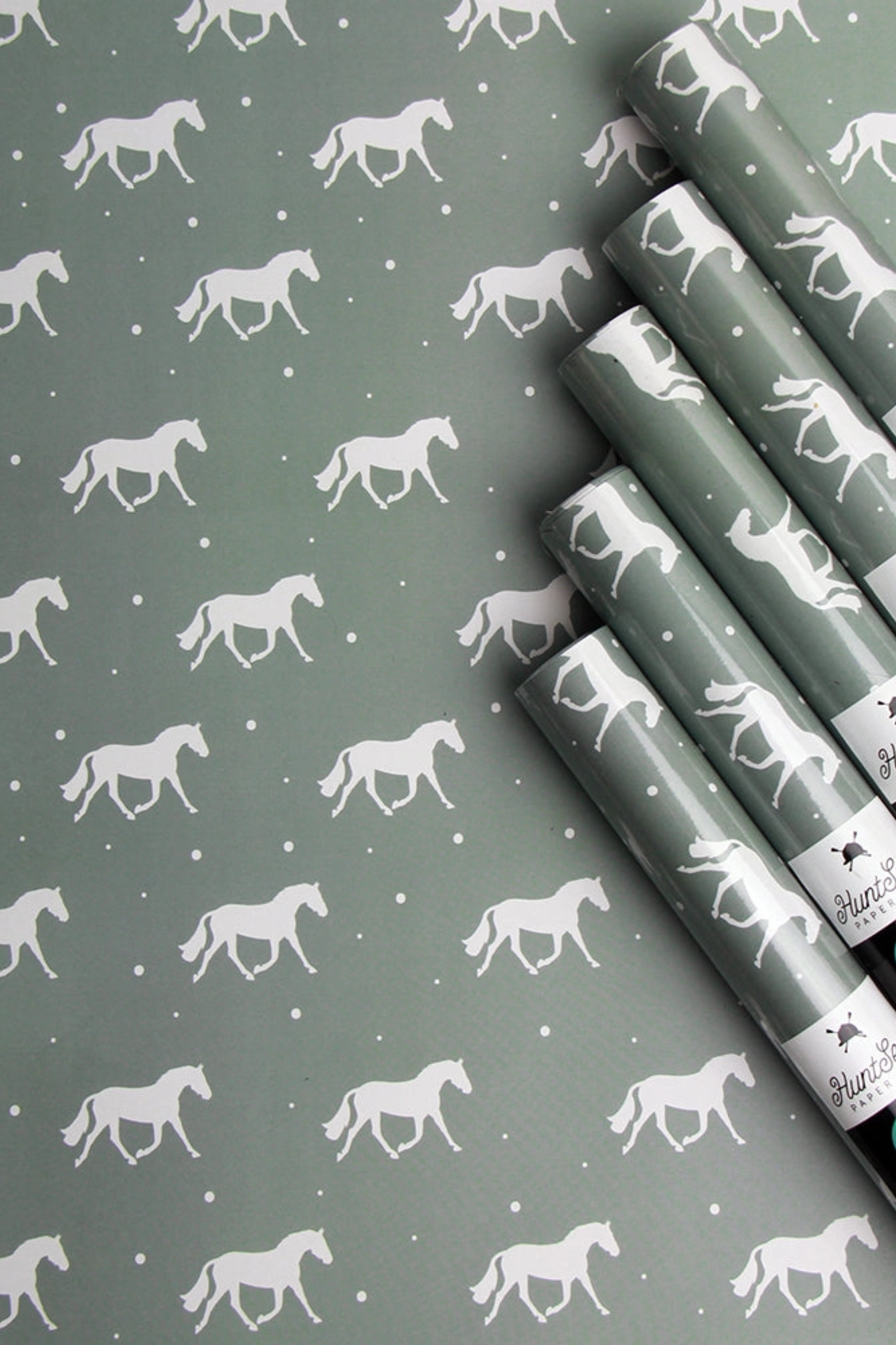 Set of three luxury equestrian gift wrap sheets featuring a repeating pattern of elegant trotting horses on a soft sage green background, printed on high-quality textured paper. Perfect horse themed wrapping paper for winter gifts, horse lovers, and equestrian events. Made in the USA. equestrian gift wrapping paper, horse wrapping paper, winter horse gift wrap sheets, sage green horse gift wrap, luxury horse themed wrapping paper, equestrian stationery, horse lover gift wrap, elegant equestrian